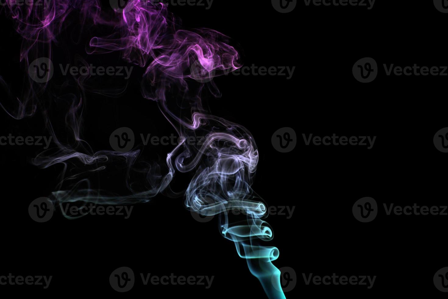 Multicolored smoke for aromatherapy relaxation on black background, beautiful swirled puffs of smoke photo