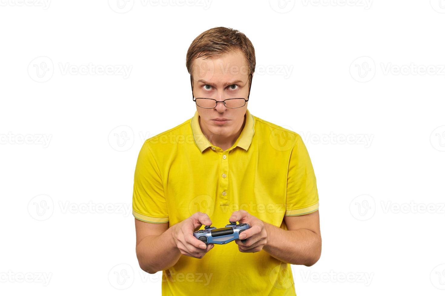 jugador geek con gafas y camiseta amarilla con gamepad, jugador de videojuegos emocionado aislado en blanco foto