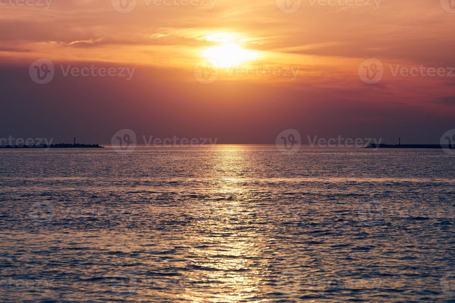 Calm sea with sunset sky, beautiful panoramic view, amazing dramatic rising sun reflected in water photo