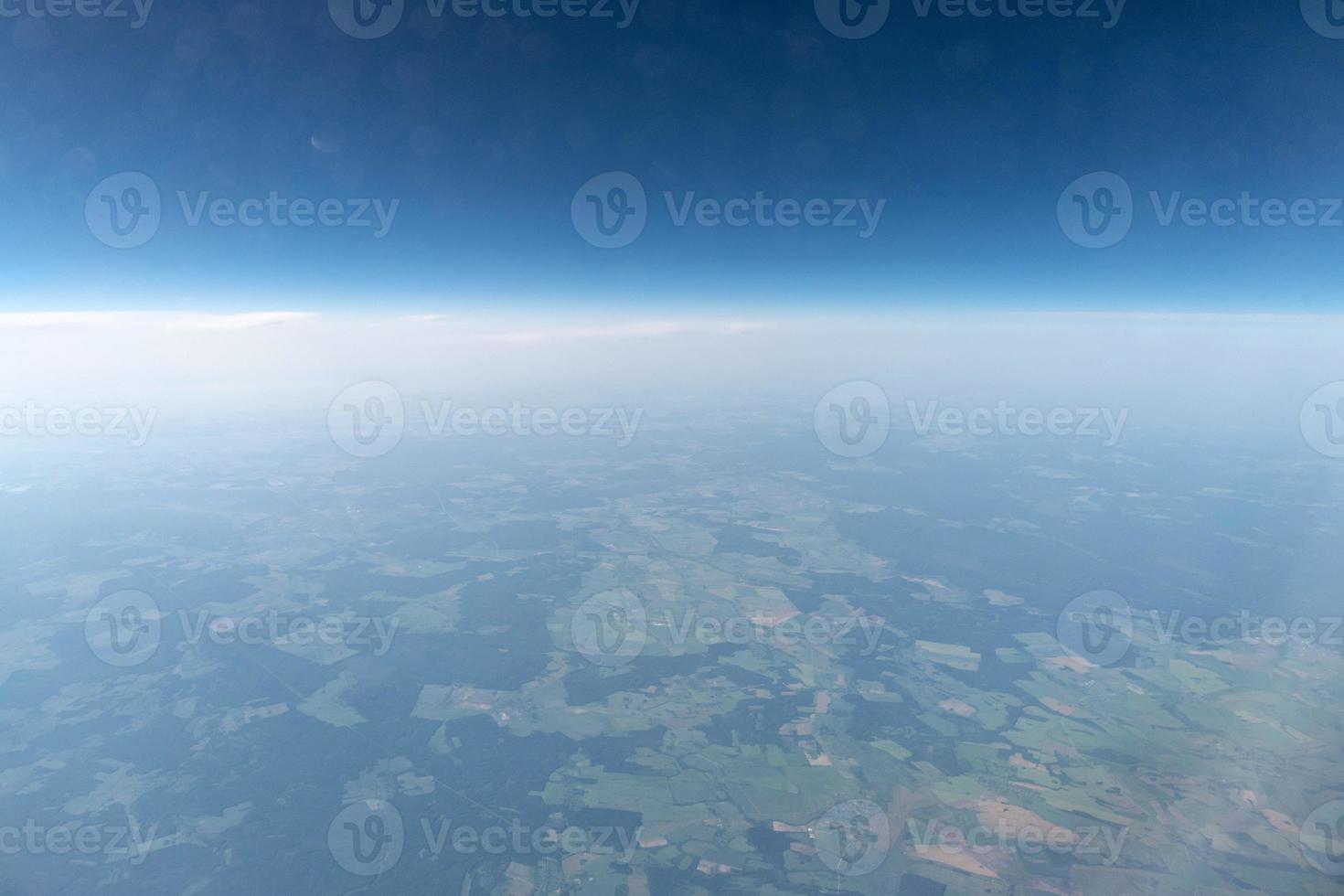 Airplane window view to cloudy sky and earth. Beautiful landscape from aircraft cabin. Flying without fear of flying, incidents and turbulence. photo