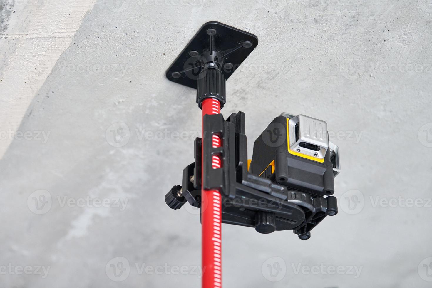 Laser level measuring tool at construction site or unfinished apartment, close up photo