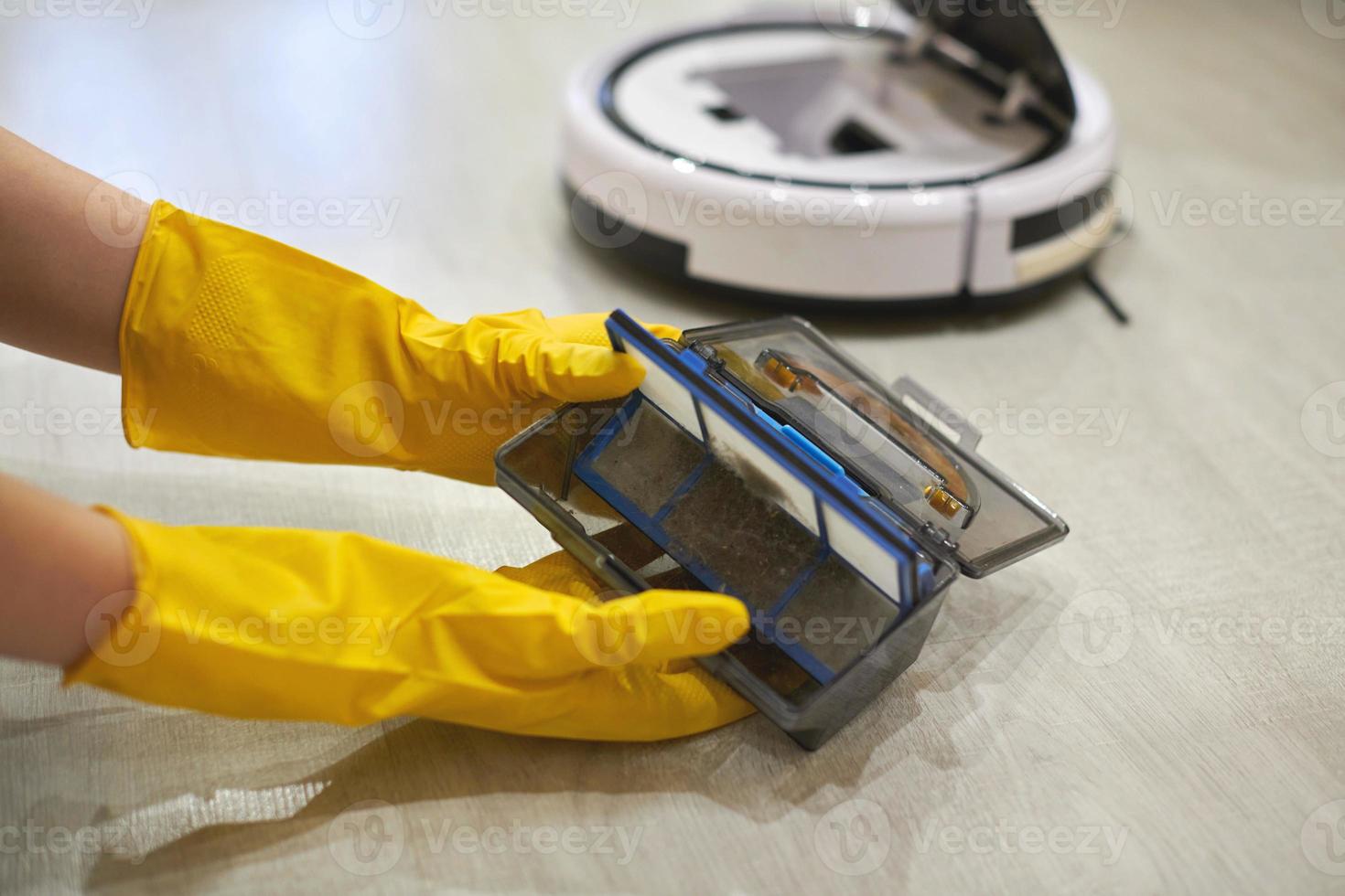 Robot vacuum cleaner, taking out filter, cleaning. Close up. photo
