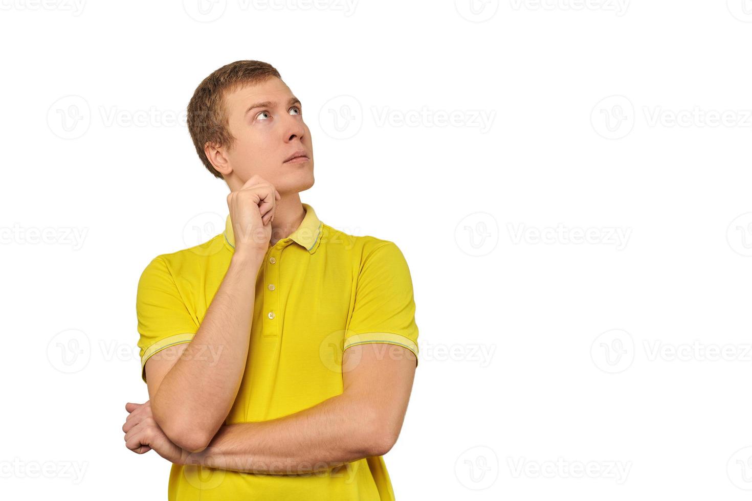 Thoughtful man in yellow T-shirt looking to right, white background, philosophical reflection photo