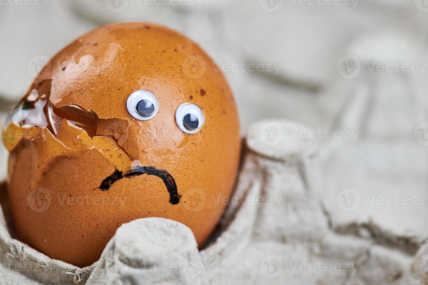 Sad cracked egg in paper egg tray photo