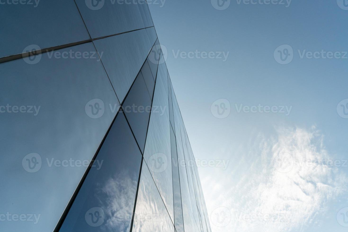 Mirror wall design of shopping center, copy space. Bottom view to modern texture of exterior decoration. Contemporary pattern of buildings. Looking up. photo