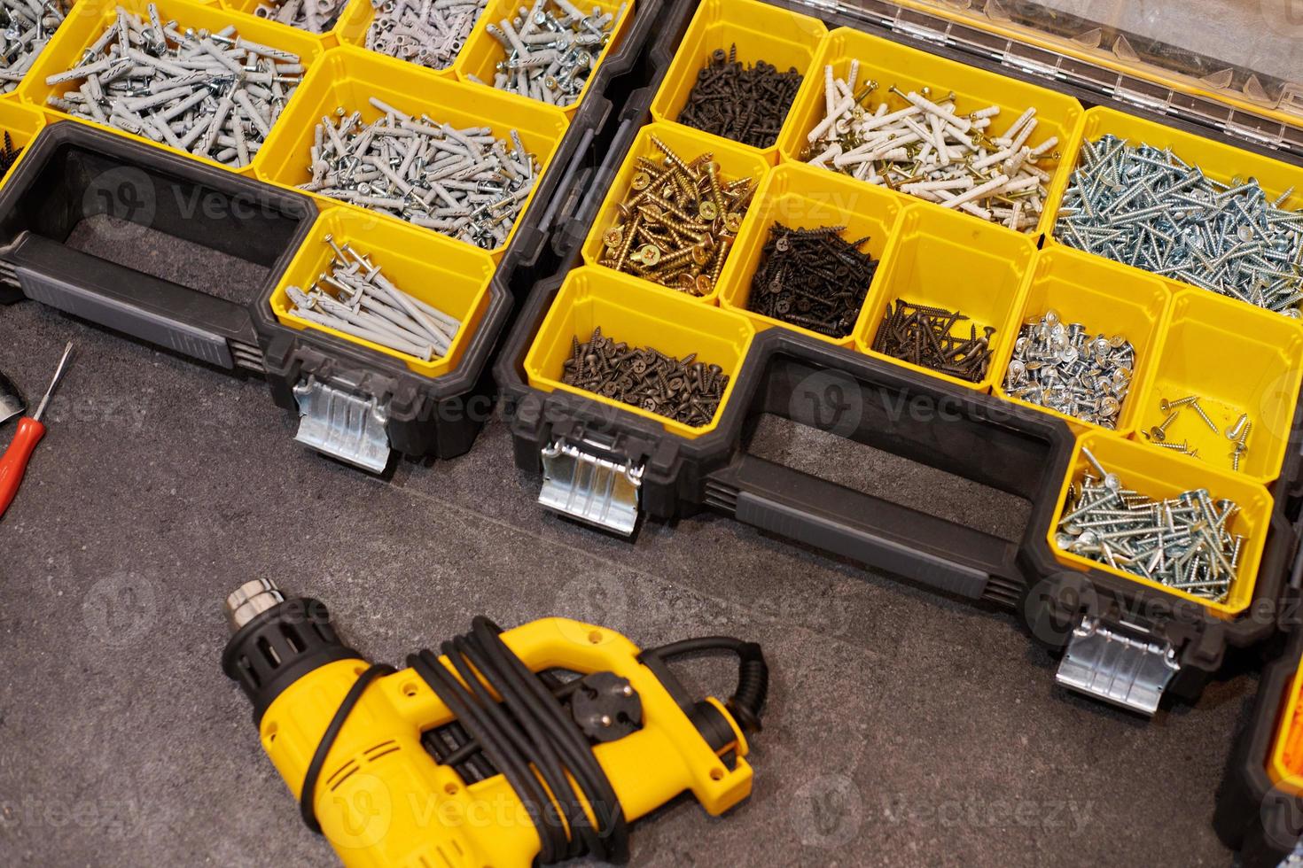 Storage boxes on floor with screws, nuts, bolts, nails and other small tools for handyman, close up photo