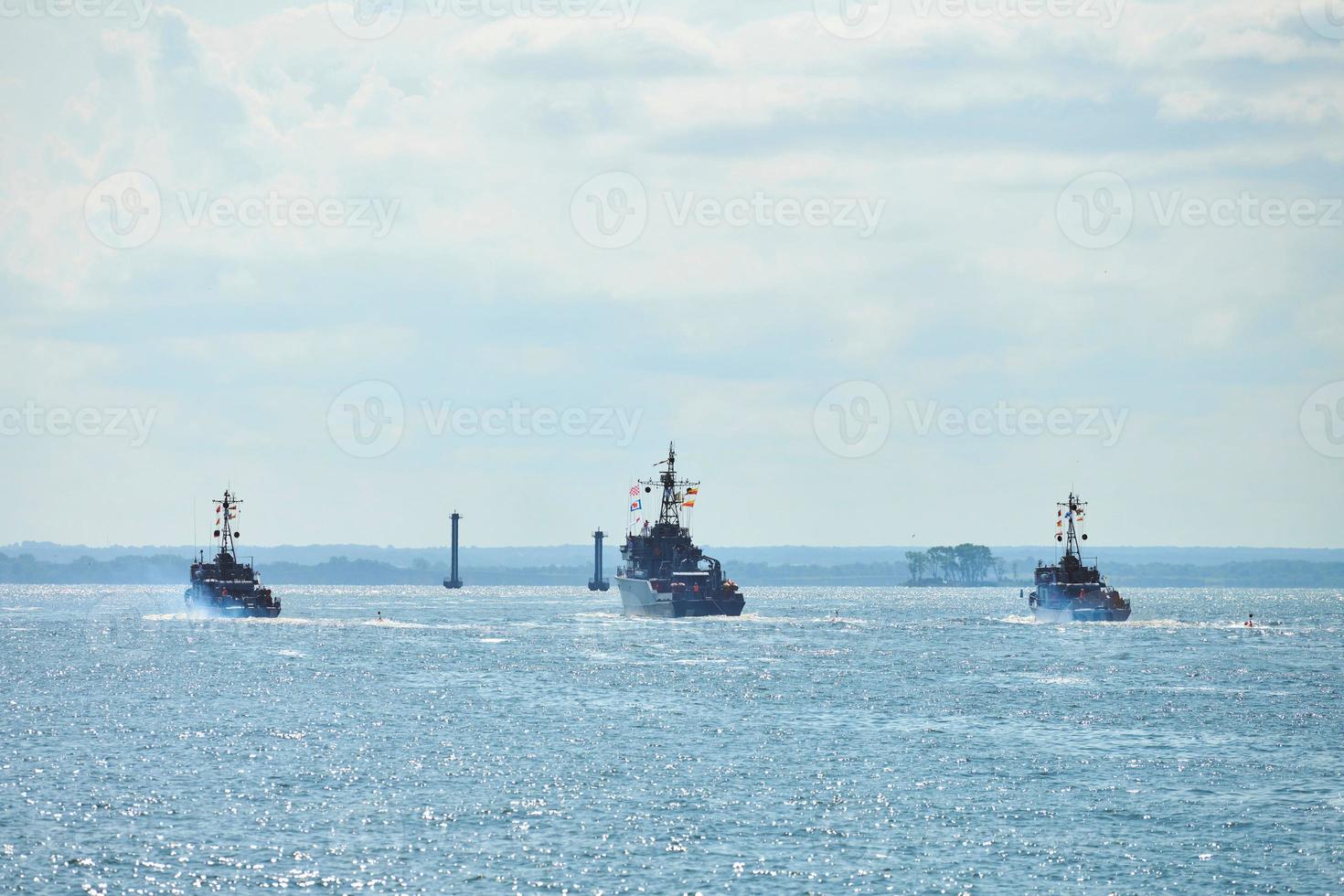 Three battleships war ships during parade and naval exercises maneuvering in bright blue sea photo