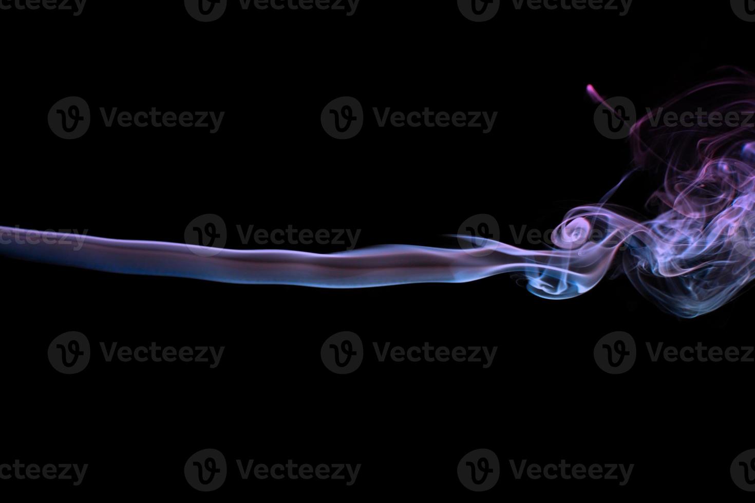 Multicolored smoke for aromatherapy relaxation on black background, beautiful swirled puffs of smoke photo