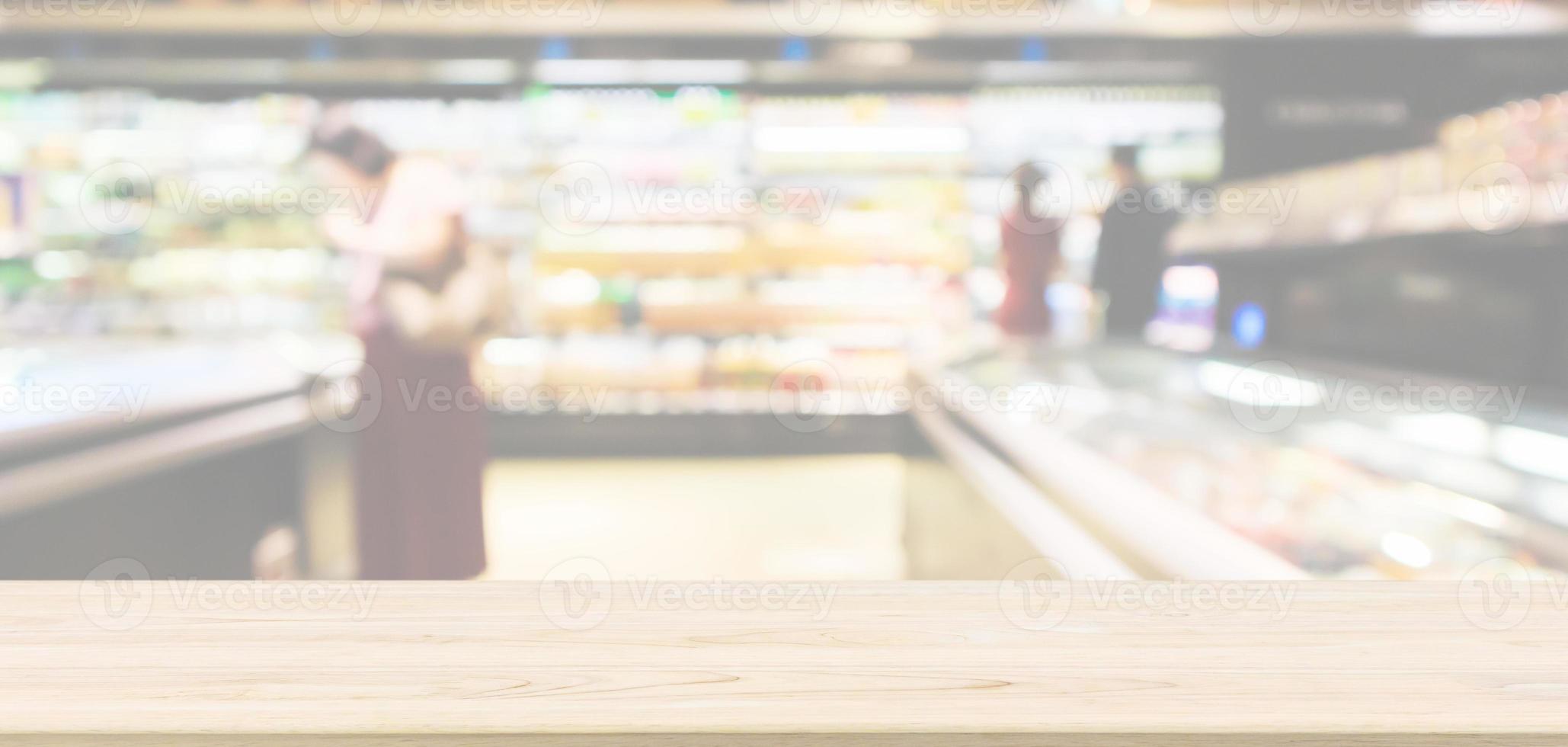 Empty wood table top with abstract supermarket aisle interior blurred defocused background with bokeh light photo