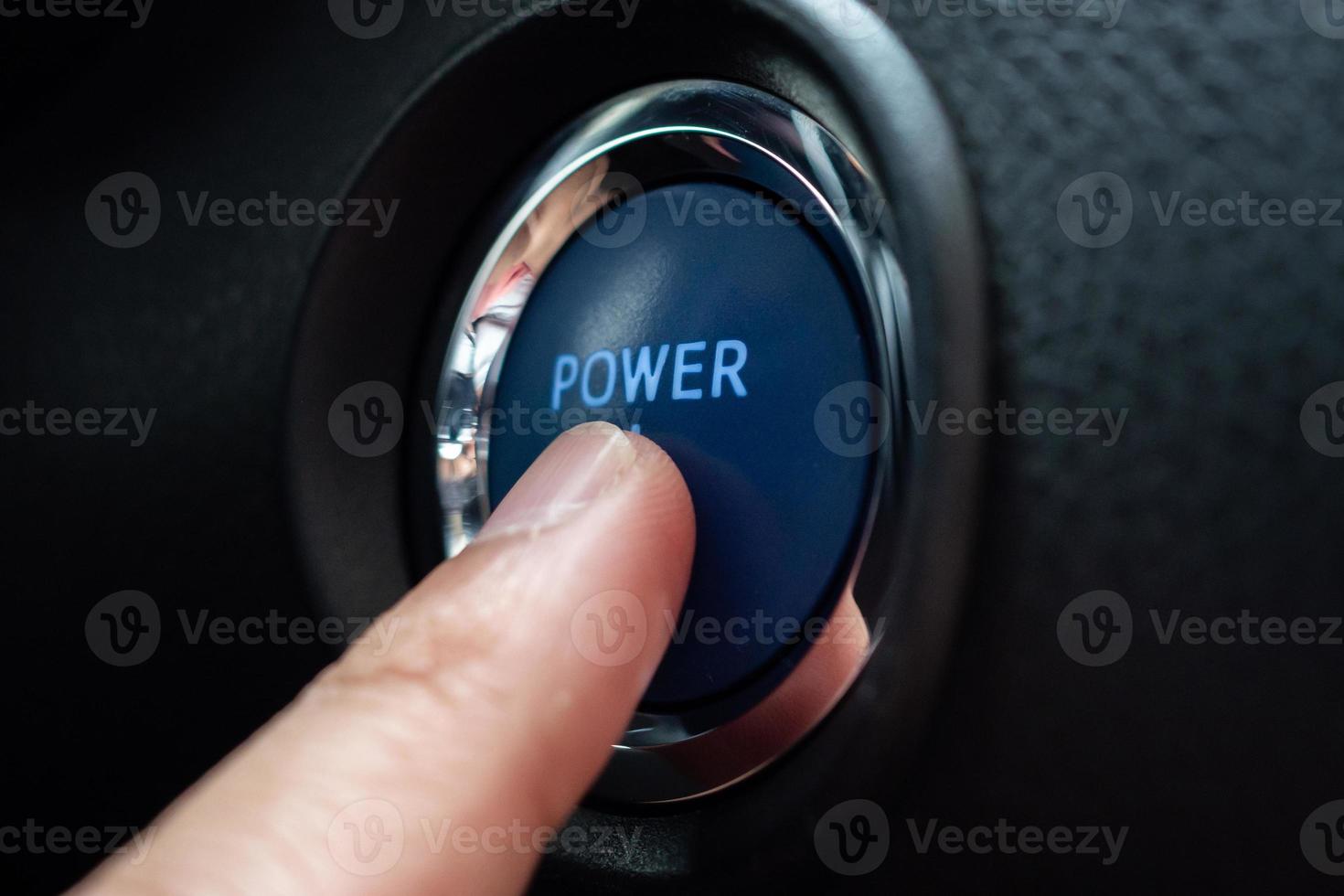 Hand push on car engine power start button close up photo