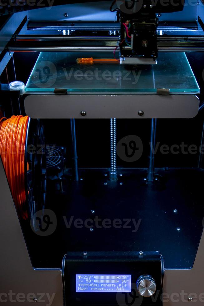 Modern 3D printer printing figure close-up macro 3d printer prints with orange plastic photo