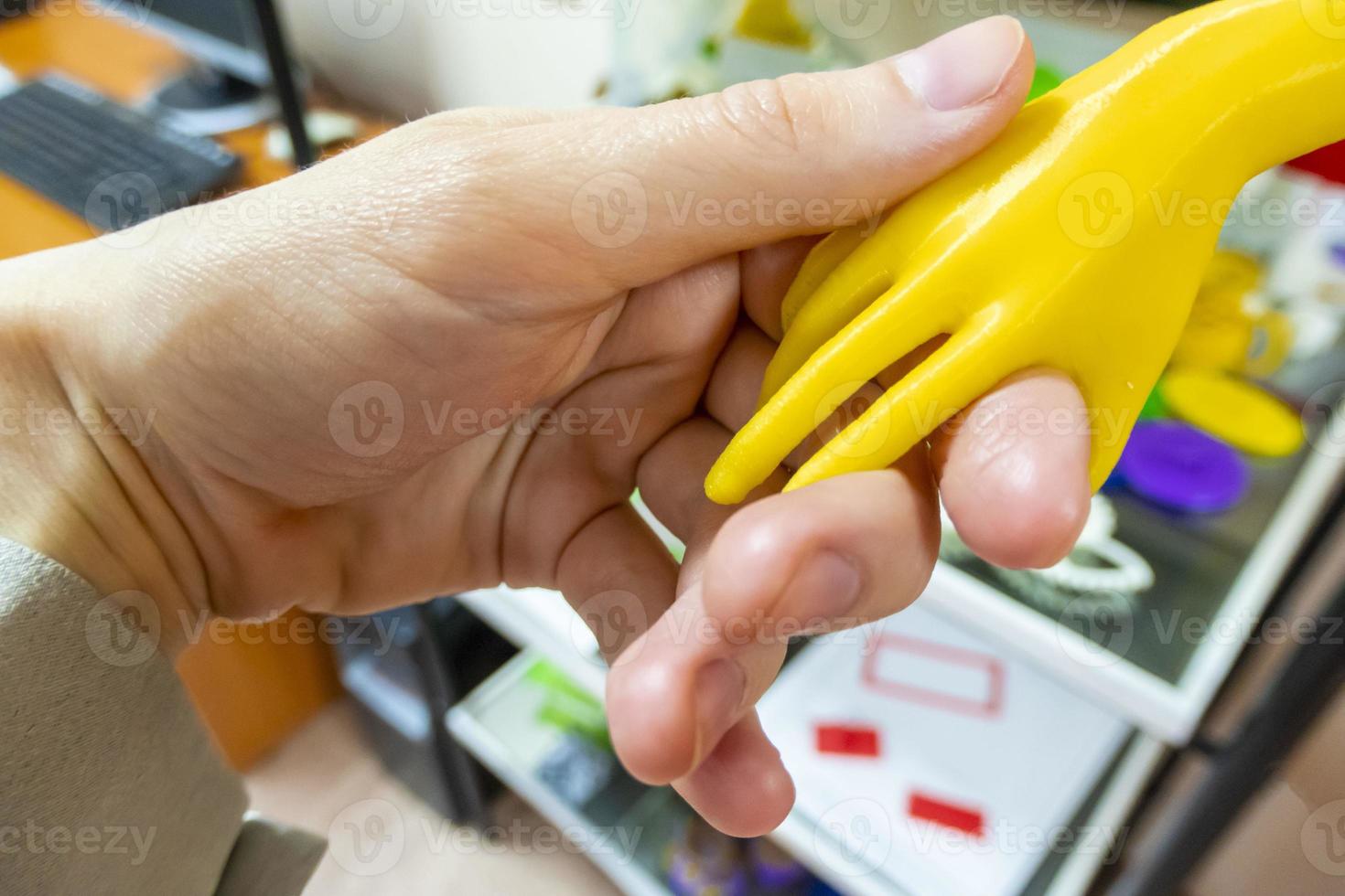 shaking a live hand and a hand printed on a 3D printer photo