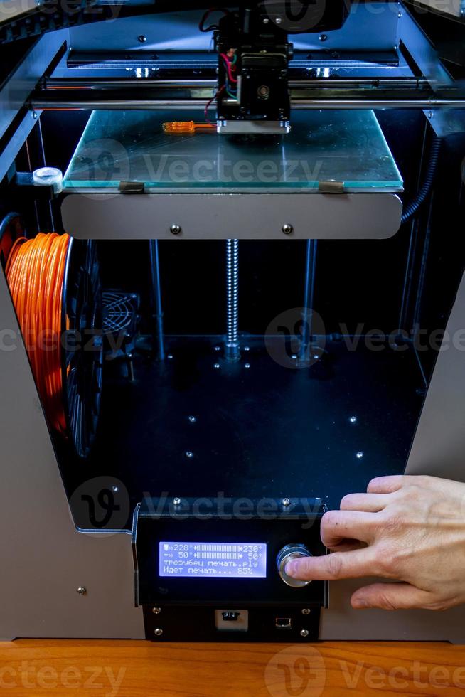 Modern 3D printer printing figure close-up macro 3d printer prints with orange plastic photo
