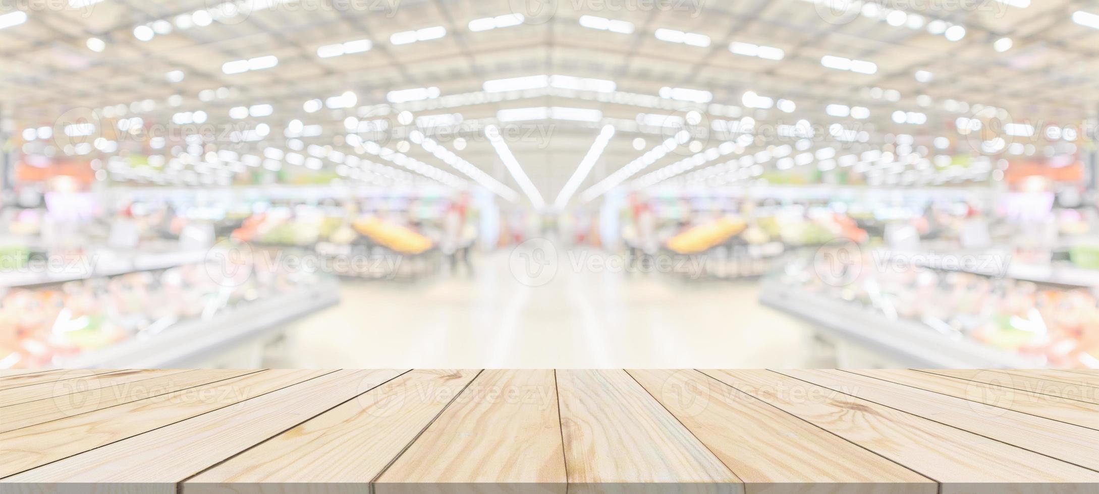 Wood table top with supermarket grocery store blurred defocused background with bokeh light for product display photo
