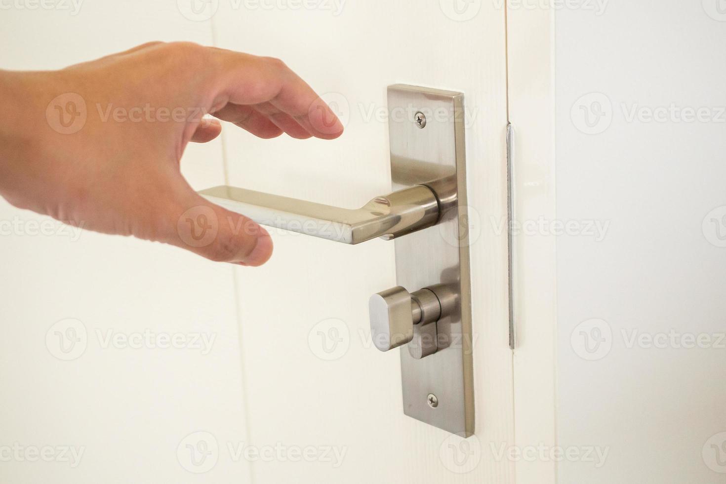 Man hand holding door handle close up photo