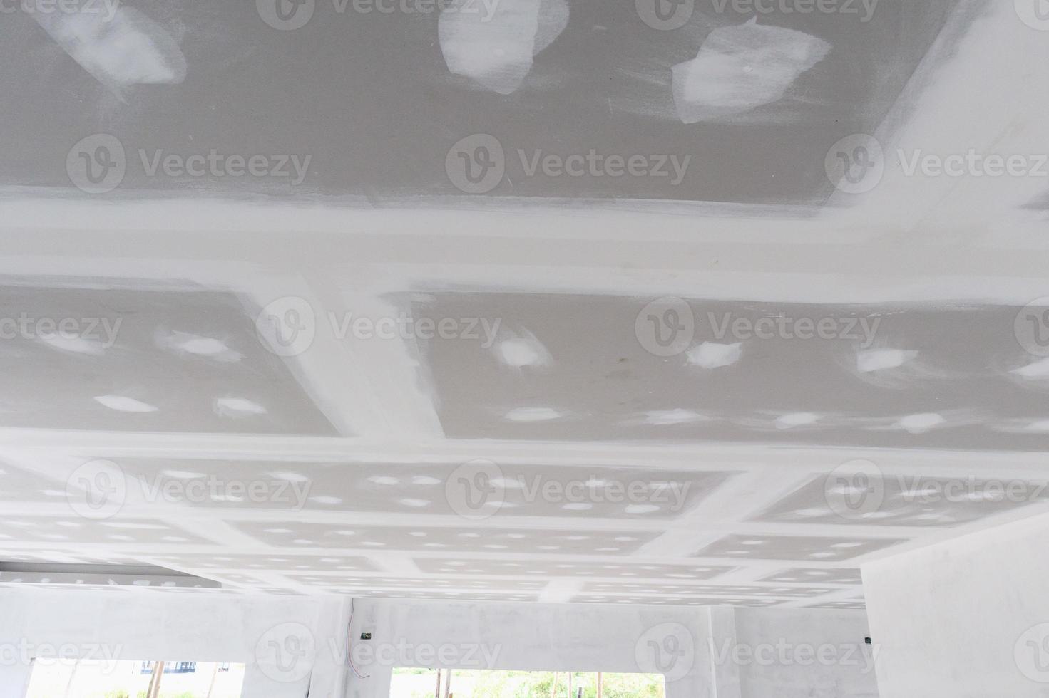 ceiling gypsum board installation at construction site photo