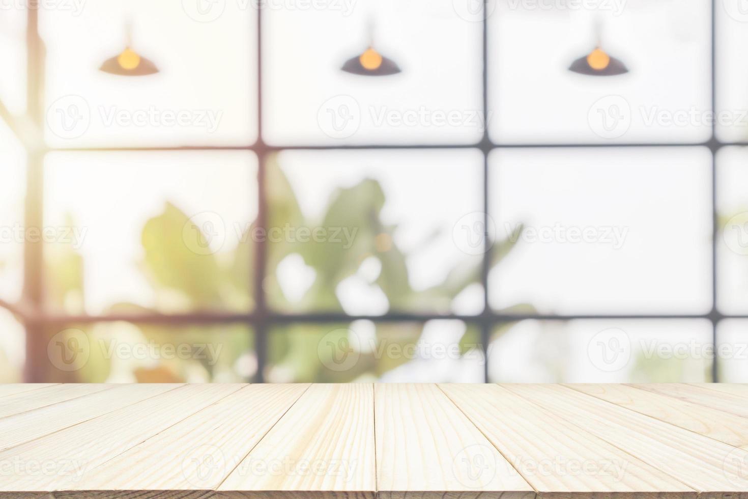 Empty wooden table top with cafe restaurant coffee shop window interior abstract blur defocused with bokeh light background for montage product display photo