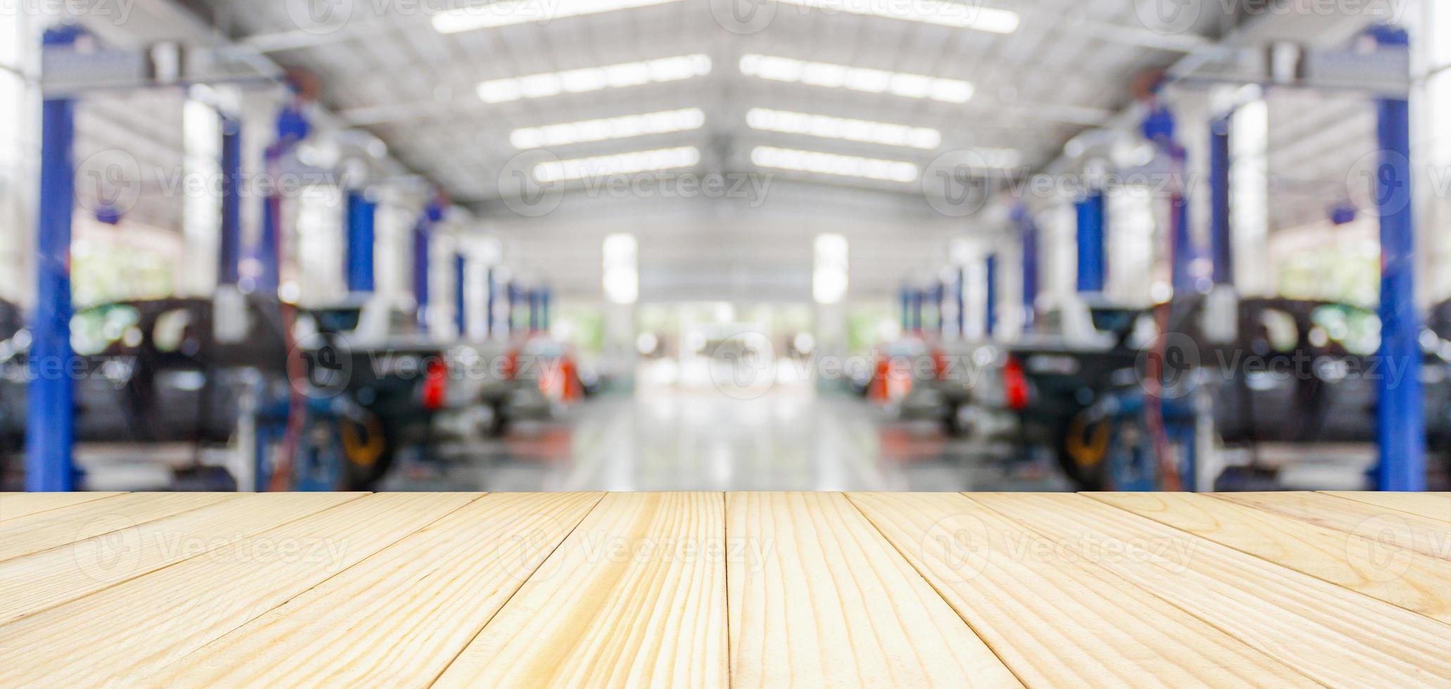 Empty wood table top with car service centre auto repair workshop blurred background photo