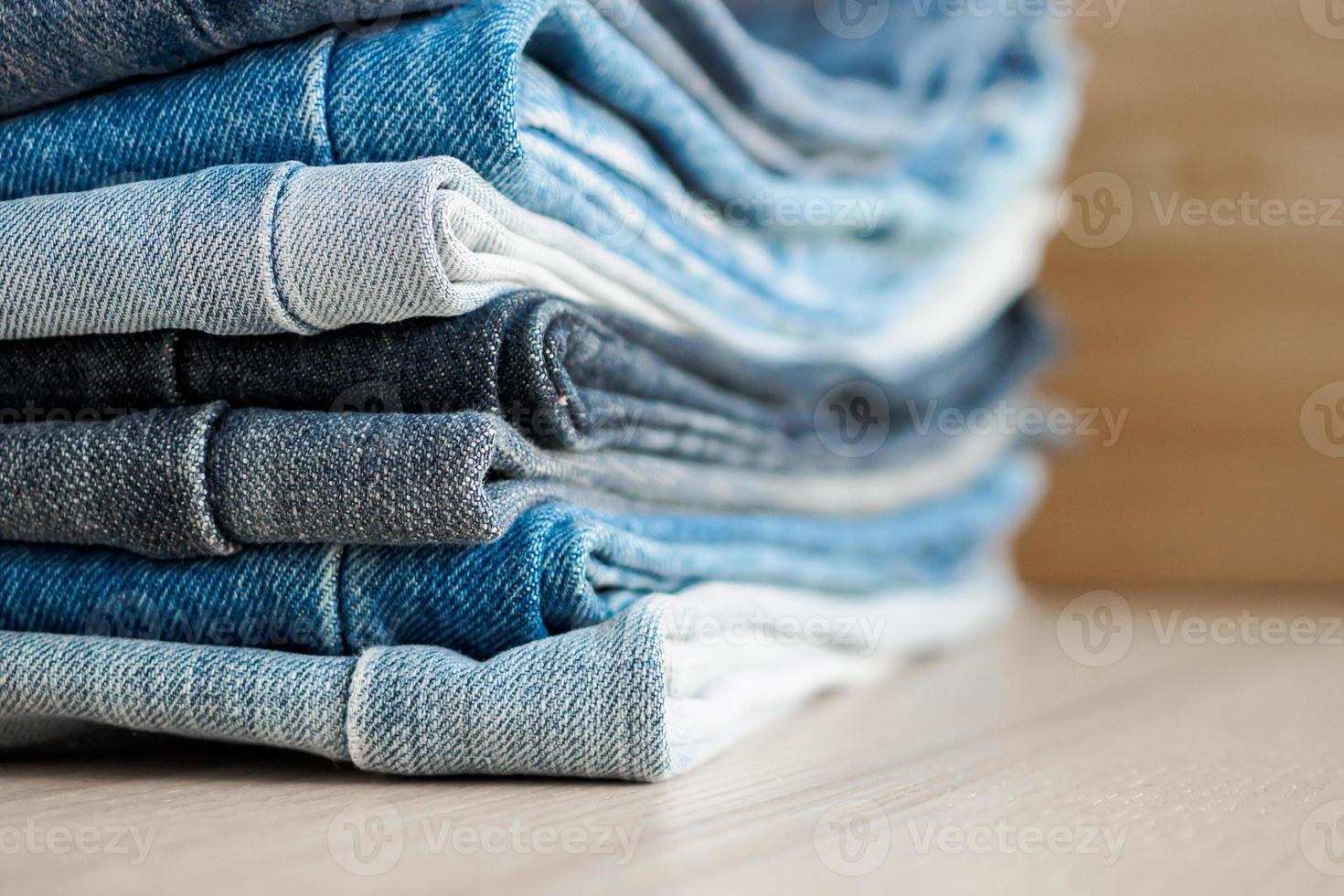 denim blue jeans stack on wood table background photo