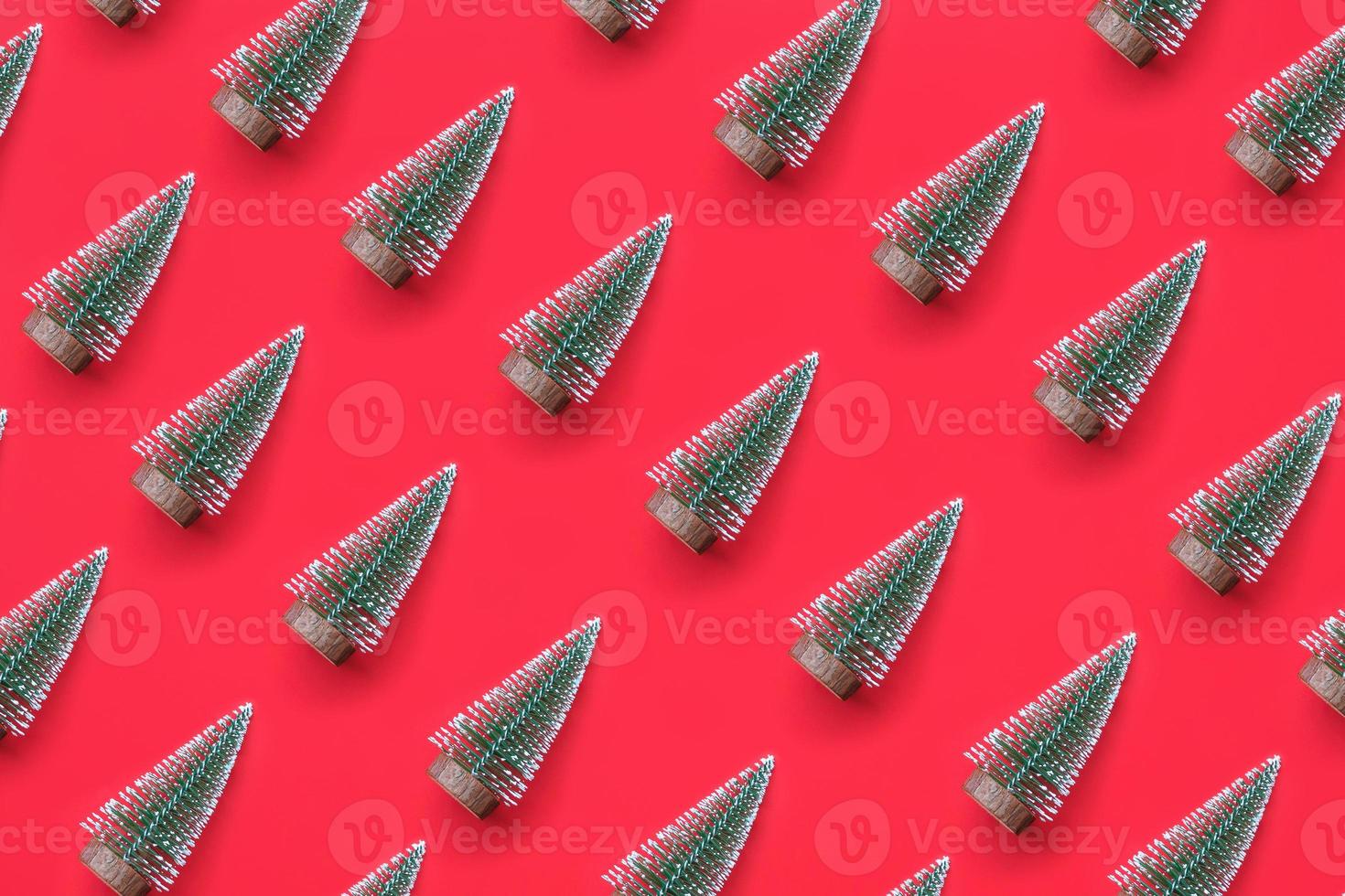 Green Christmas tree pattern minimal flatlay on red background new year holiday celebration concept photo