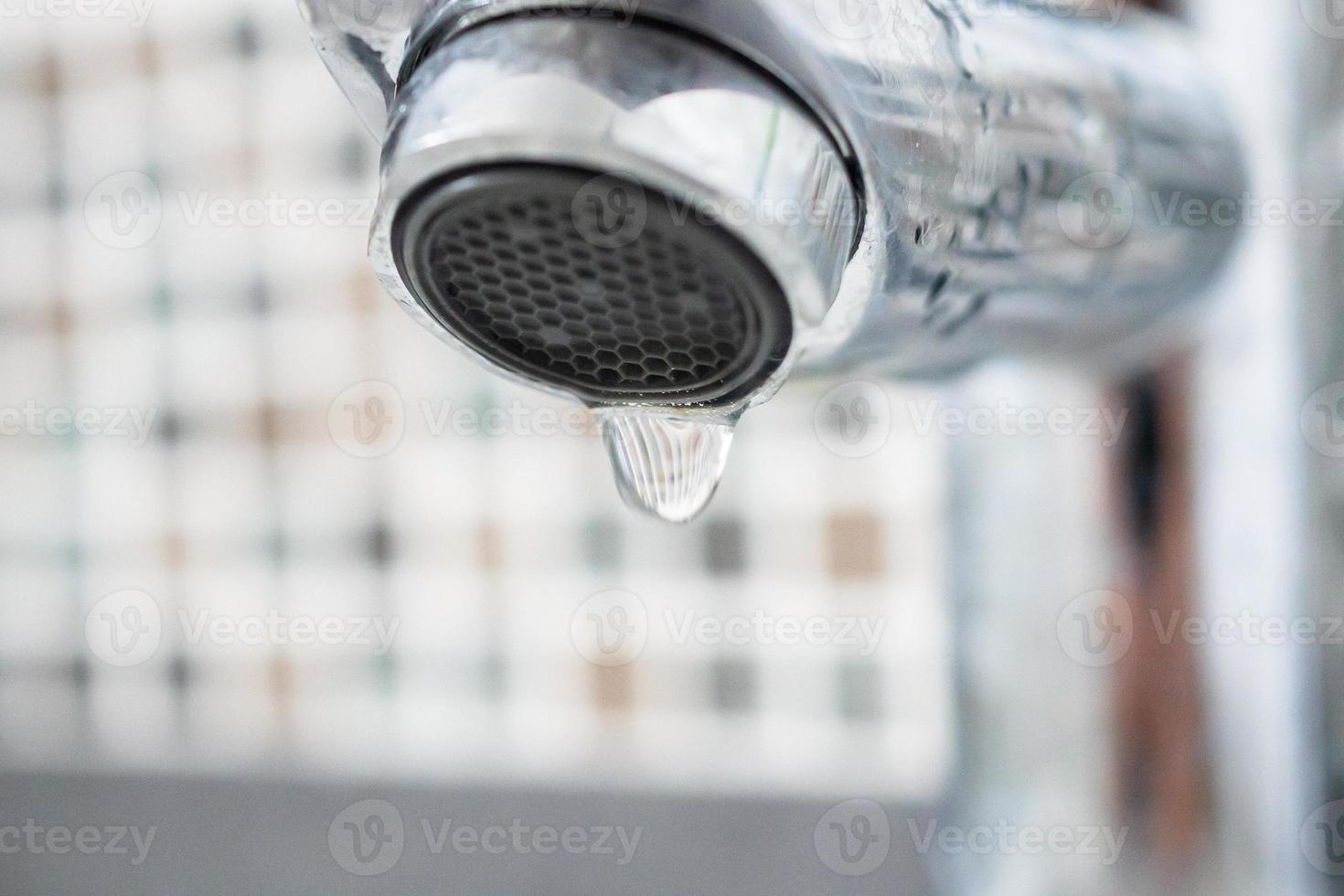 Close up faucet with water drop photo