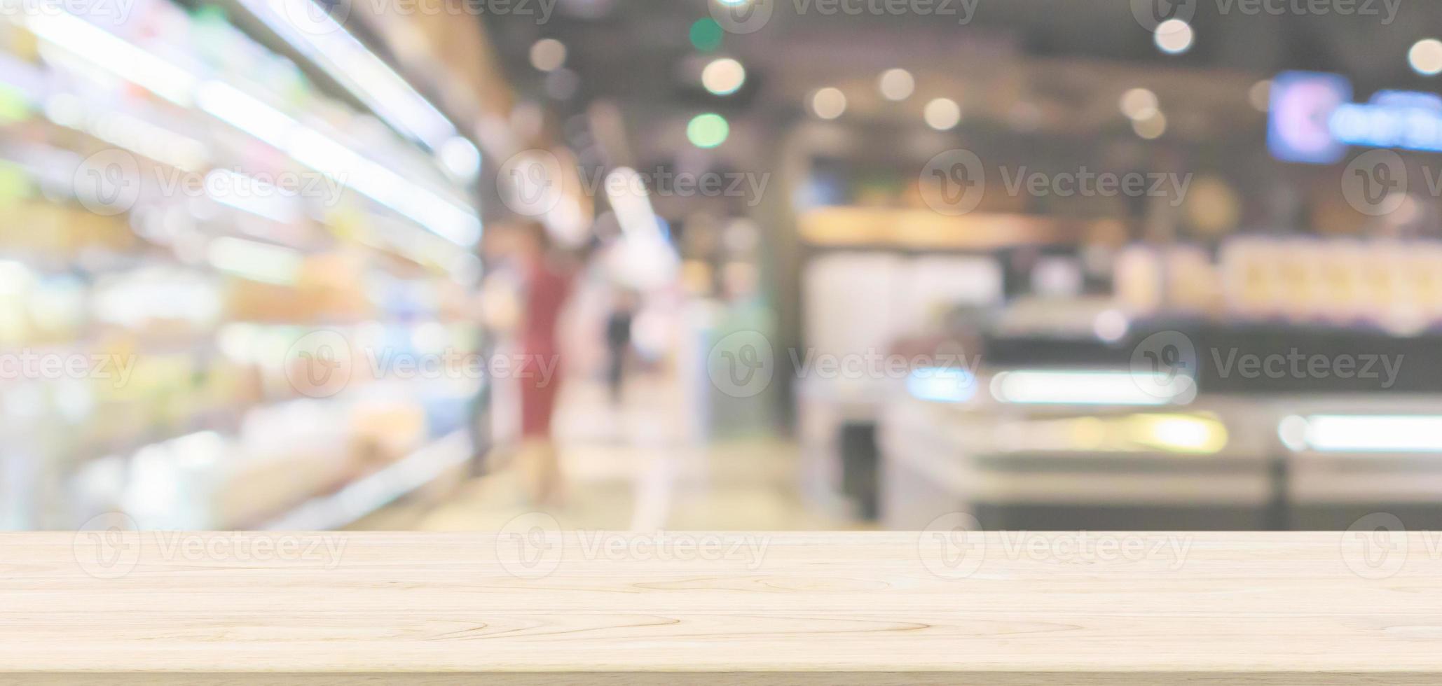 Empty wood table top with abstract supermarket aisle interior blurred defocused background with bokeh light photo