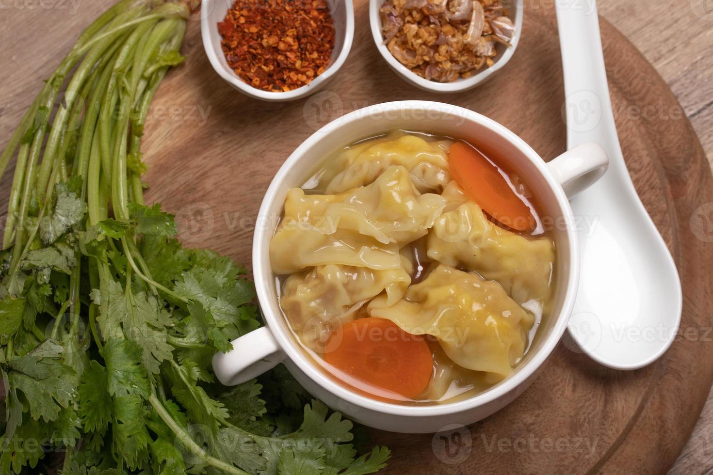 albóndigas de camarones en caldo claro y albóndigas en la mesa, albóndigas de wonton chino foto