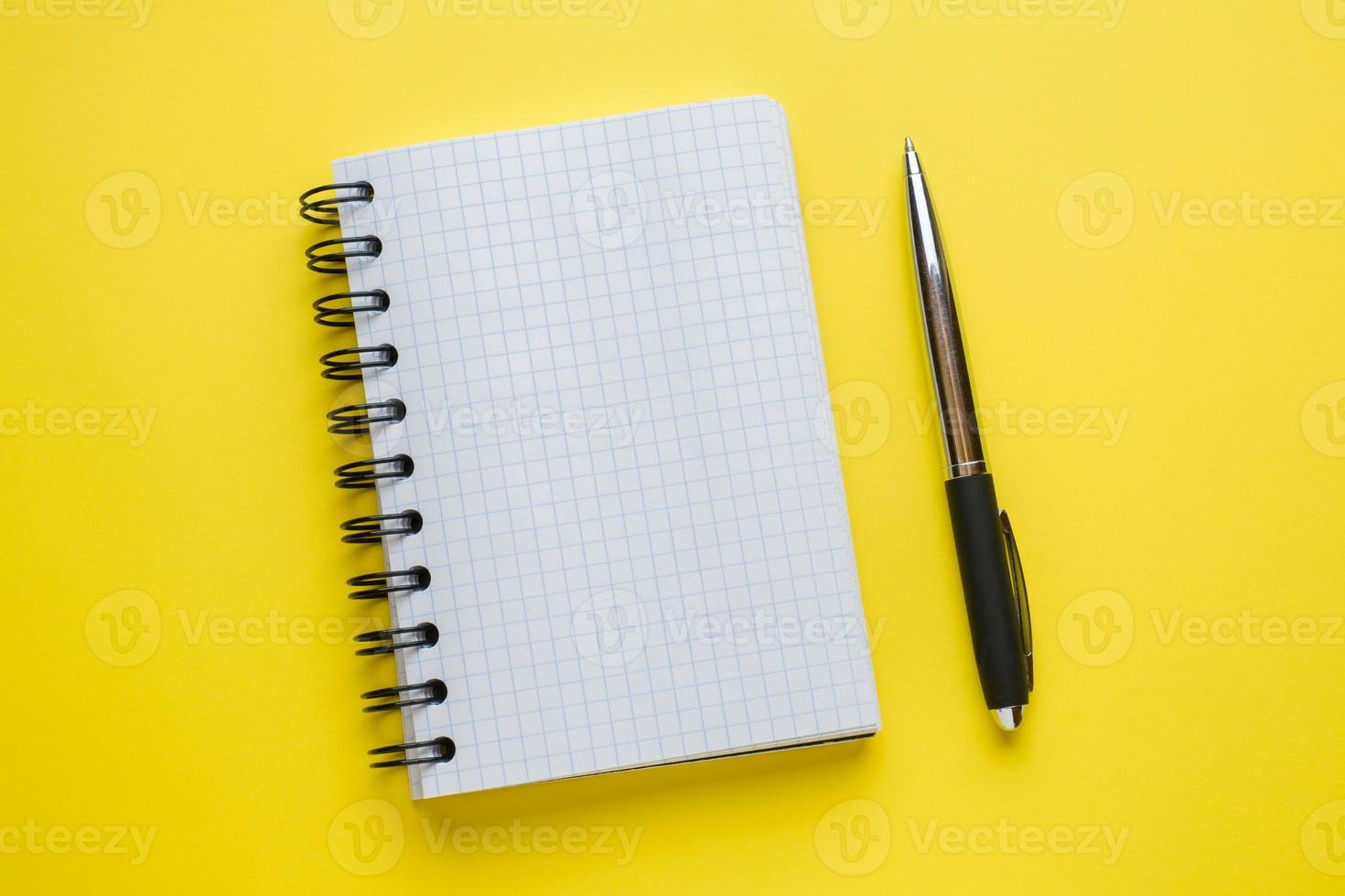 Notepad for text on yellow table with copy space. Education and office concept. photo