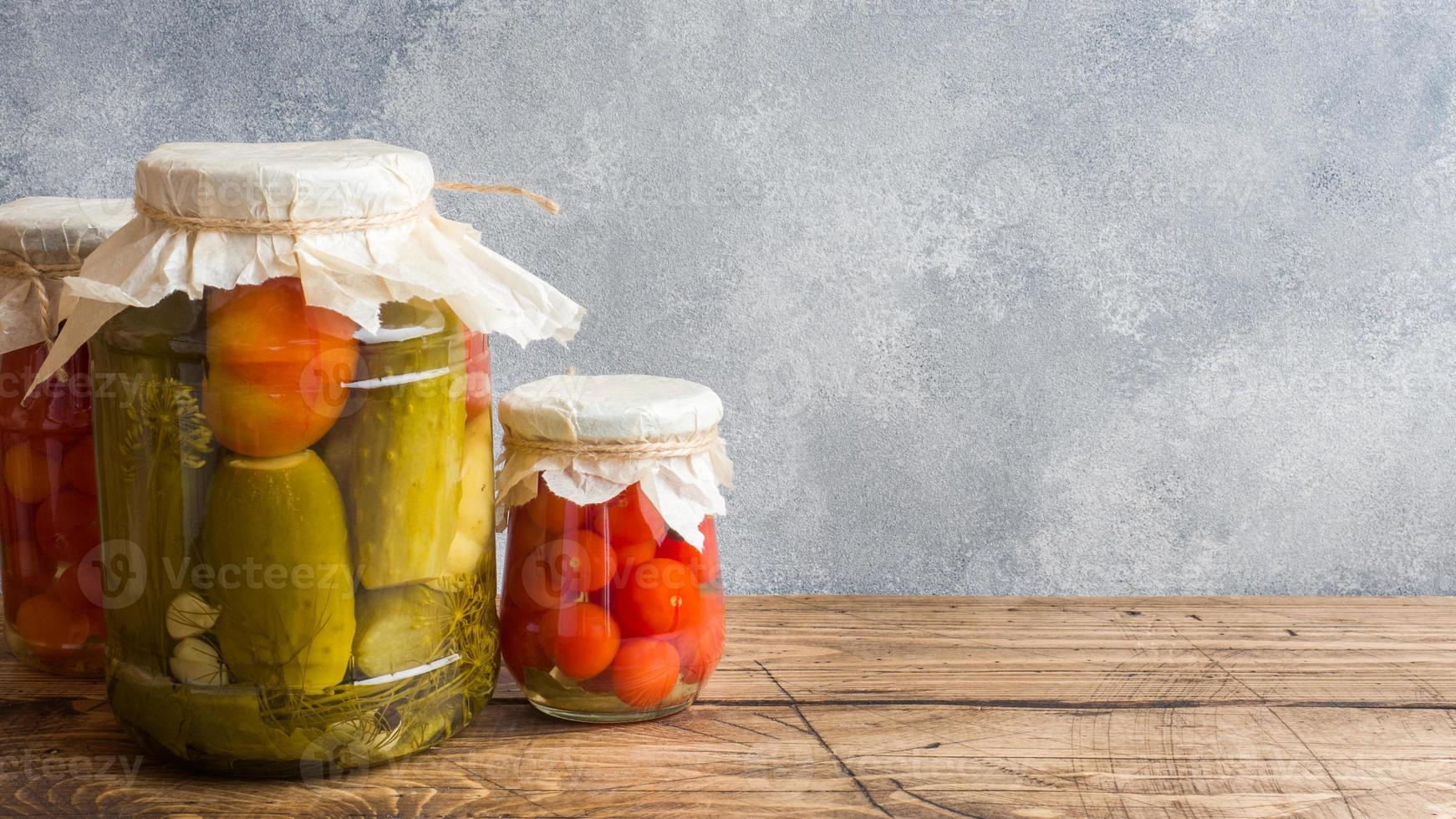 conservas de verduras caseras en latas. tomates y pepinos en escabeche al estilo rural. copie el espacio foto