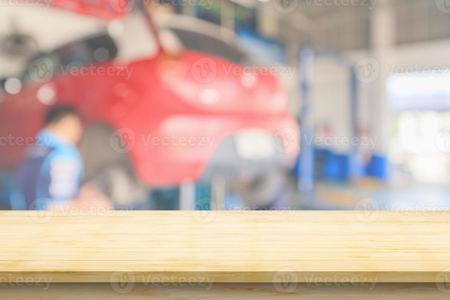 Empty wood table top with car service centre auto repair workshop blurred background photo