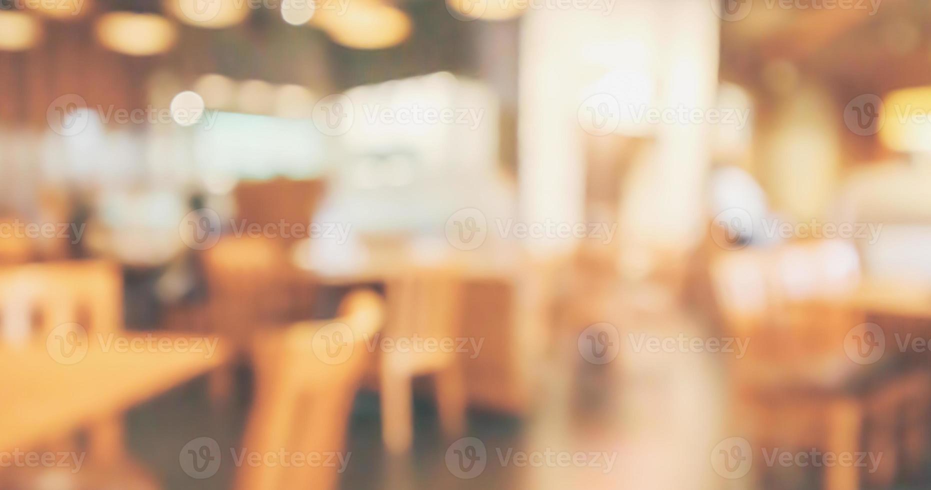 el interior del restaurante con el cliente y la mesa de madera desdibujan el fondo abstracto con la luz del bokeh foto