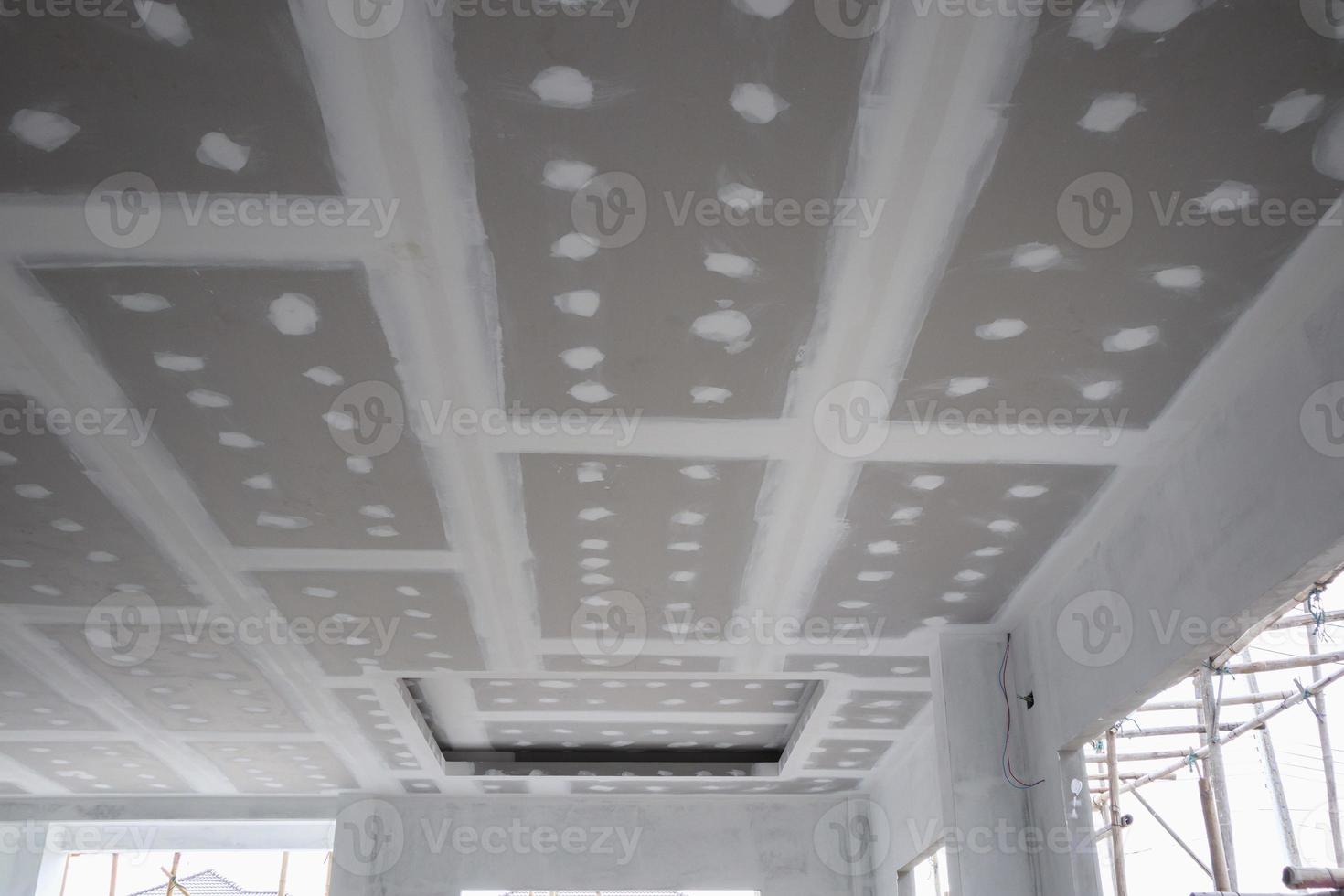 ceiling gypsum board installation at construction site photo