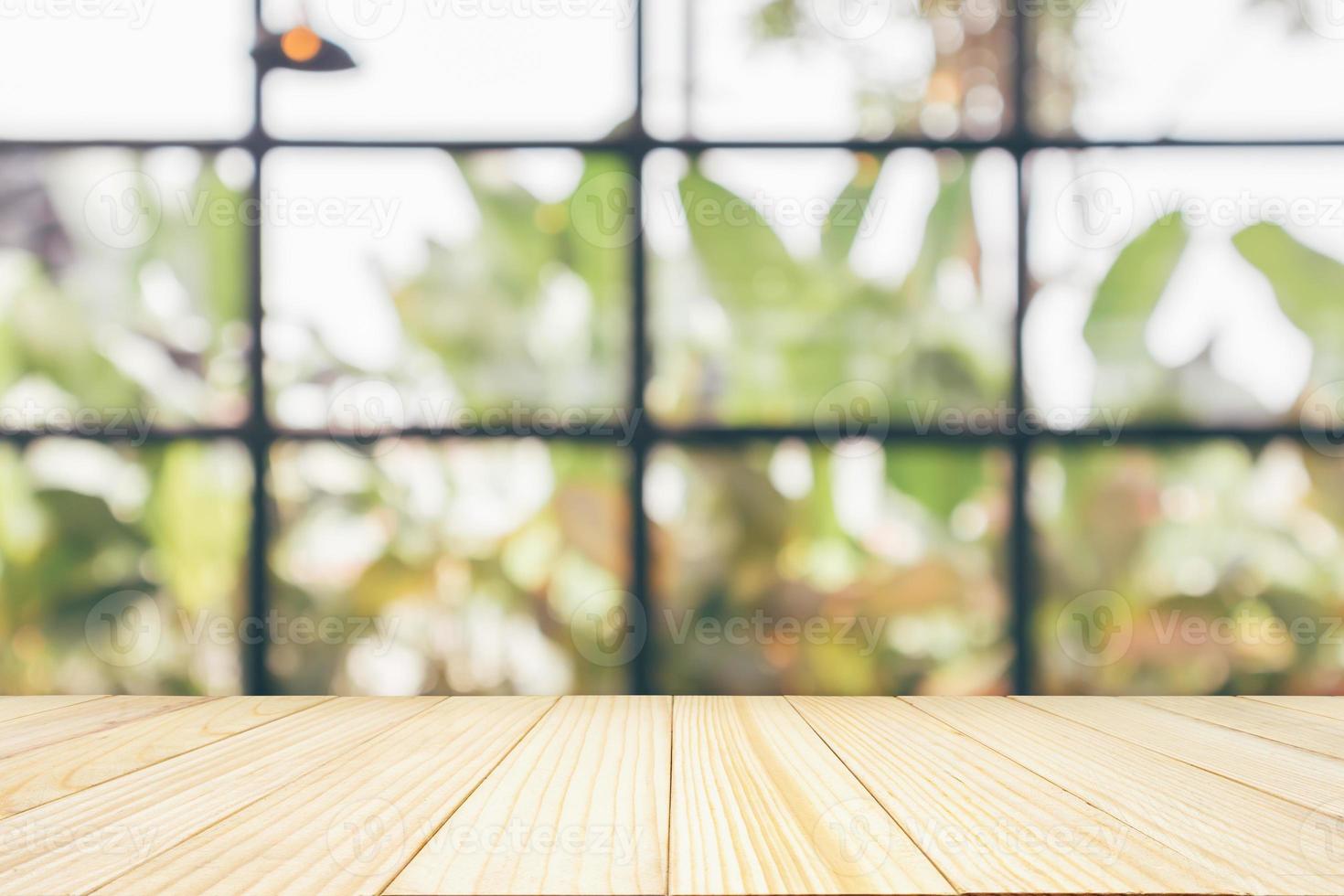 mesa de madera vacía con cafetería restaurante o ventana de cafetería interior borroso abstracto desenfocado con fondo de luz bokeh para exhibición de productos de montaje foto