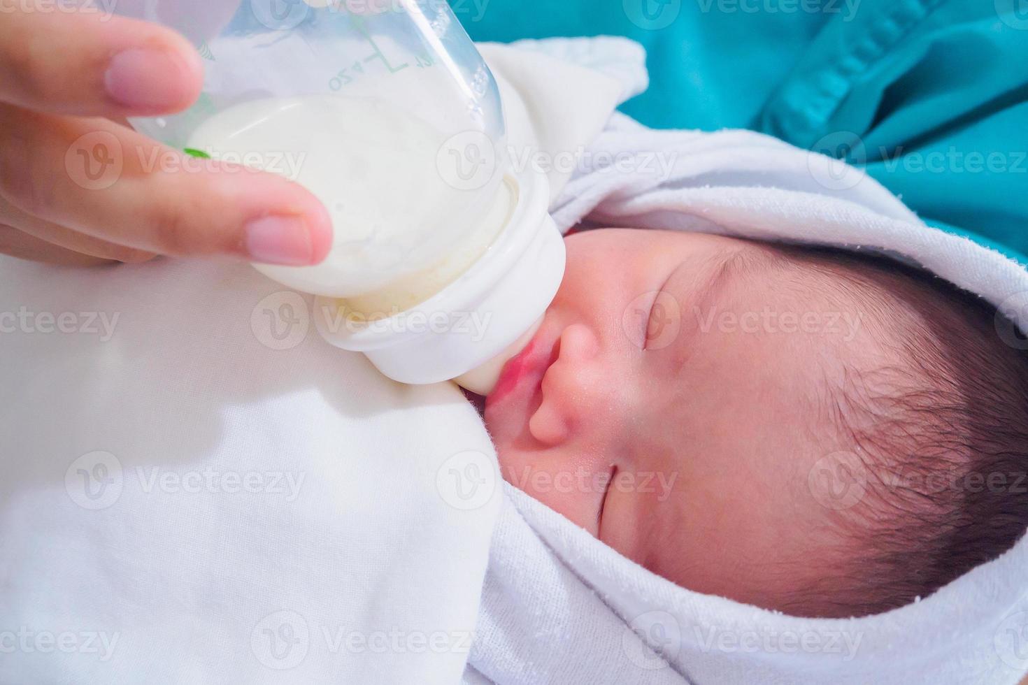 Mother feeding newborn baby from the bottle photo