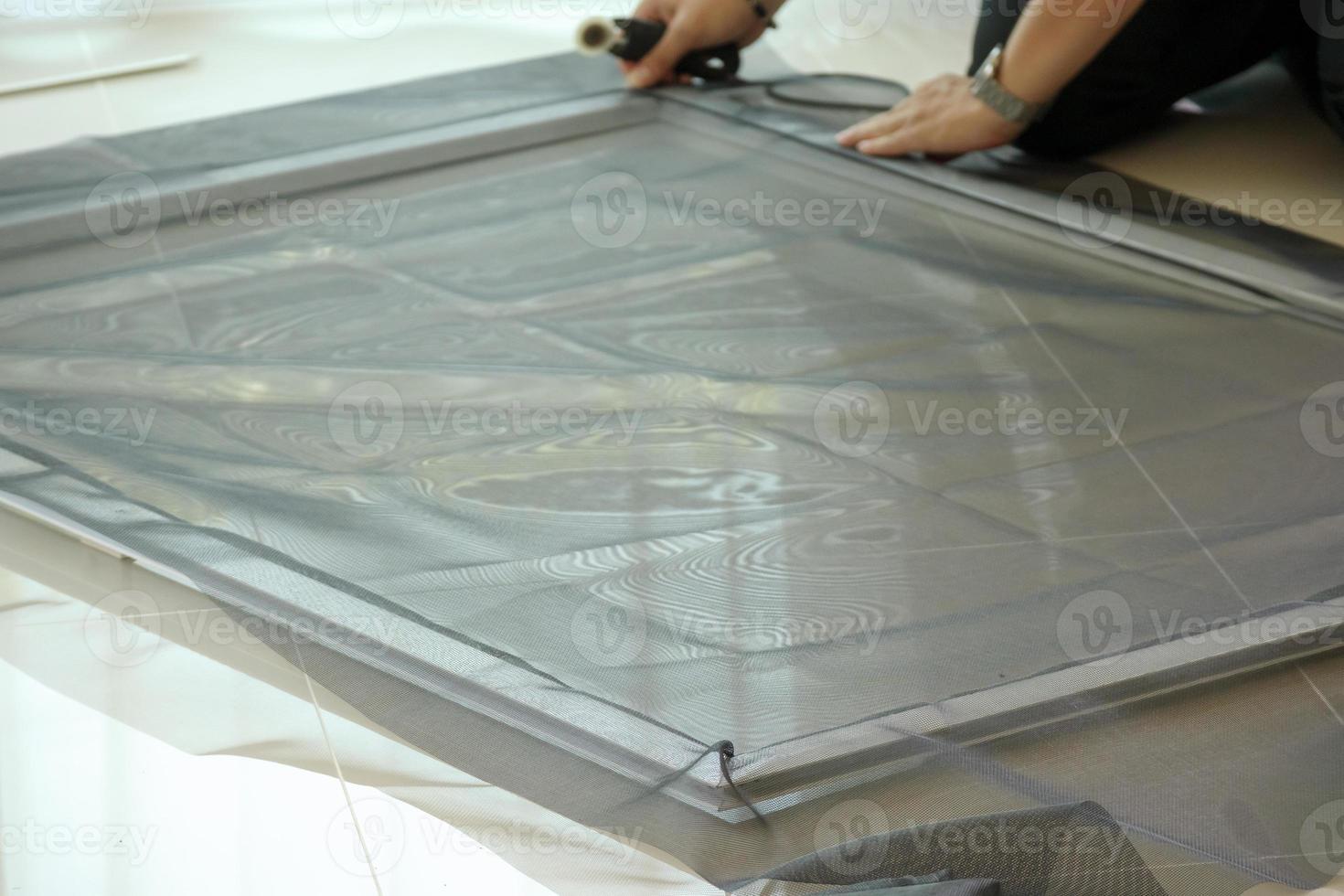 man install mosquito net wire screen on house window protection against insect photo