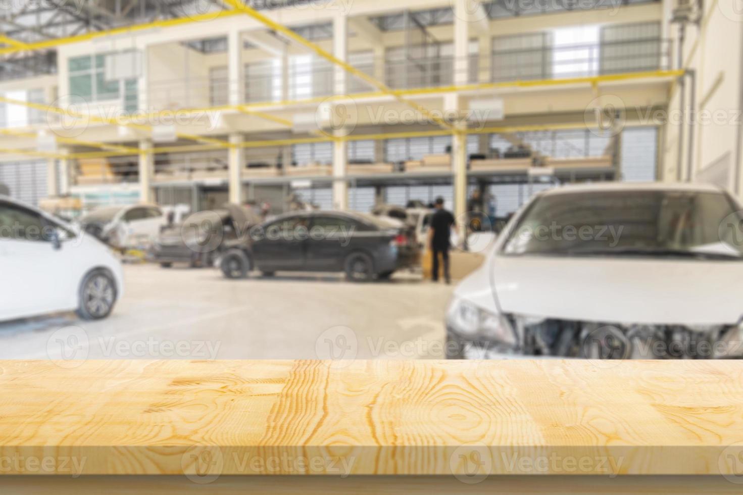 Empty wood table top with car service centre auto repair workshop blurred background photo