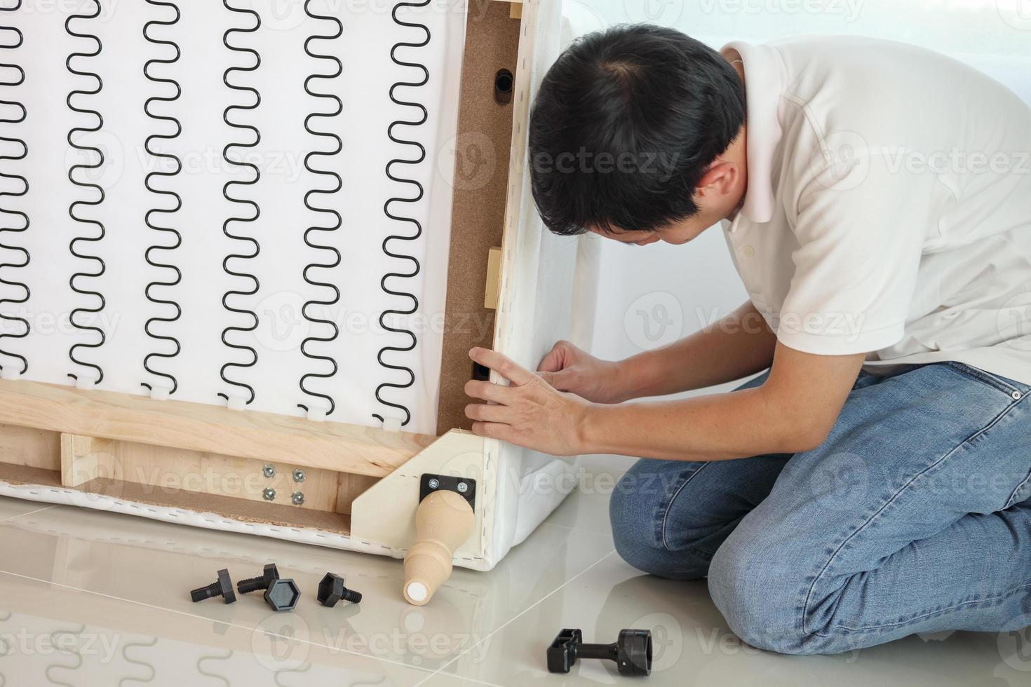 Man assembling sofa furniture at home photo