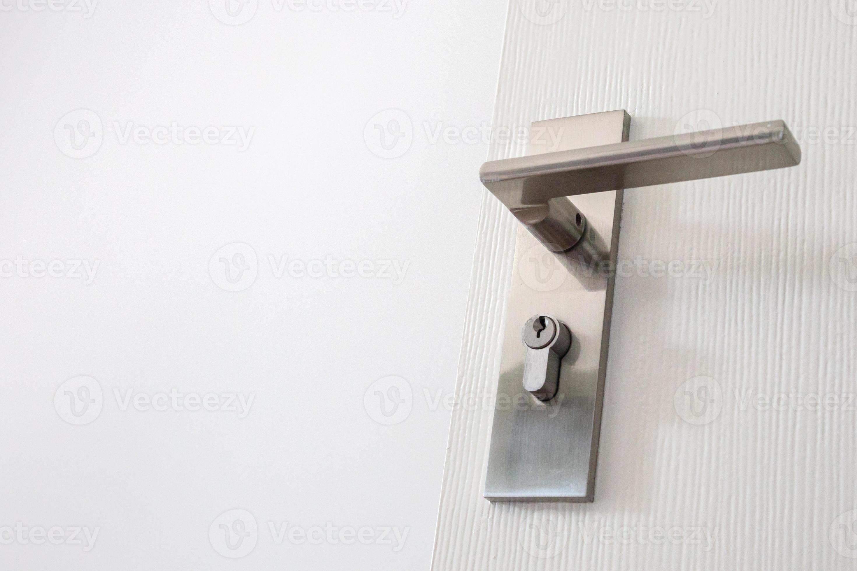 Modern door handle with keyhole on white door 12809385 Stock Photo at