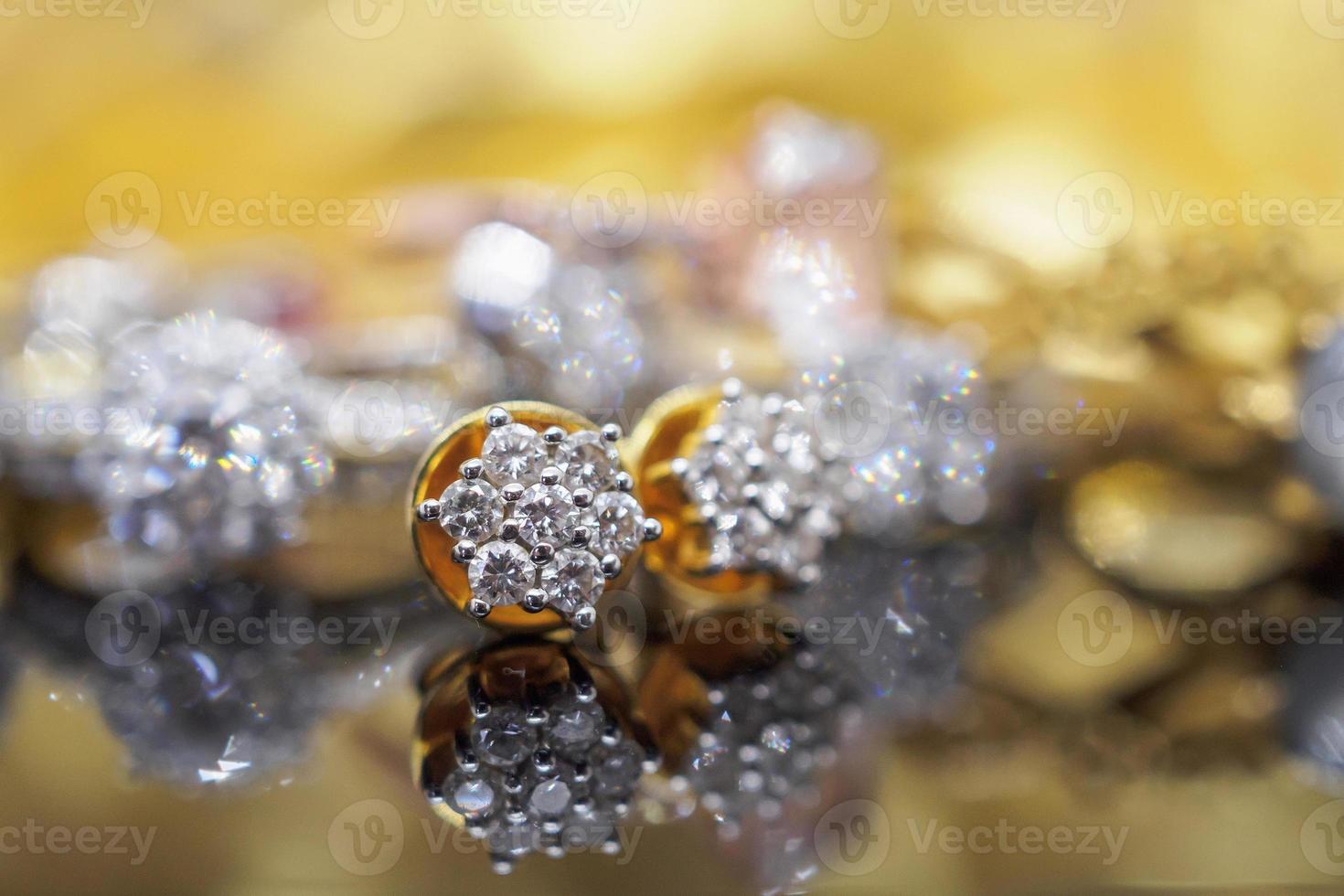 Luxury gold Jewelry diamond earrings with reflection on black background photo