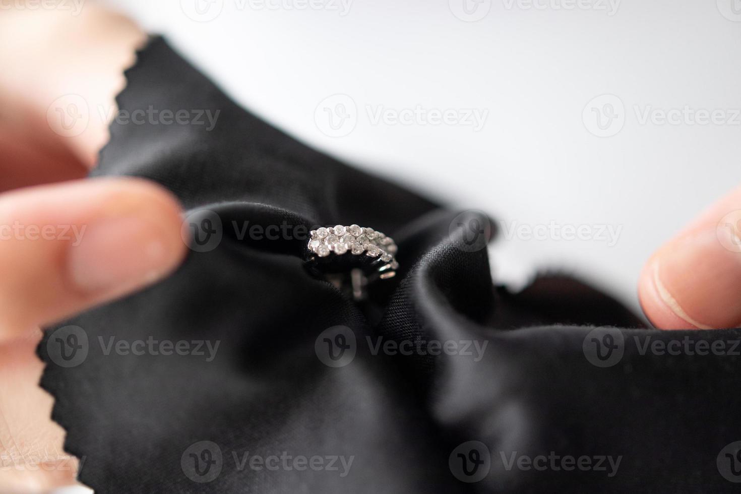 Jeweller cleaning jewelry diamond earrings with fabric cloth photo