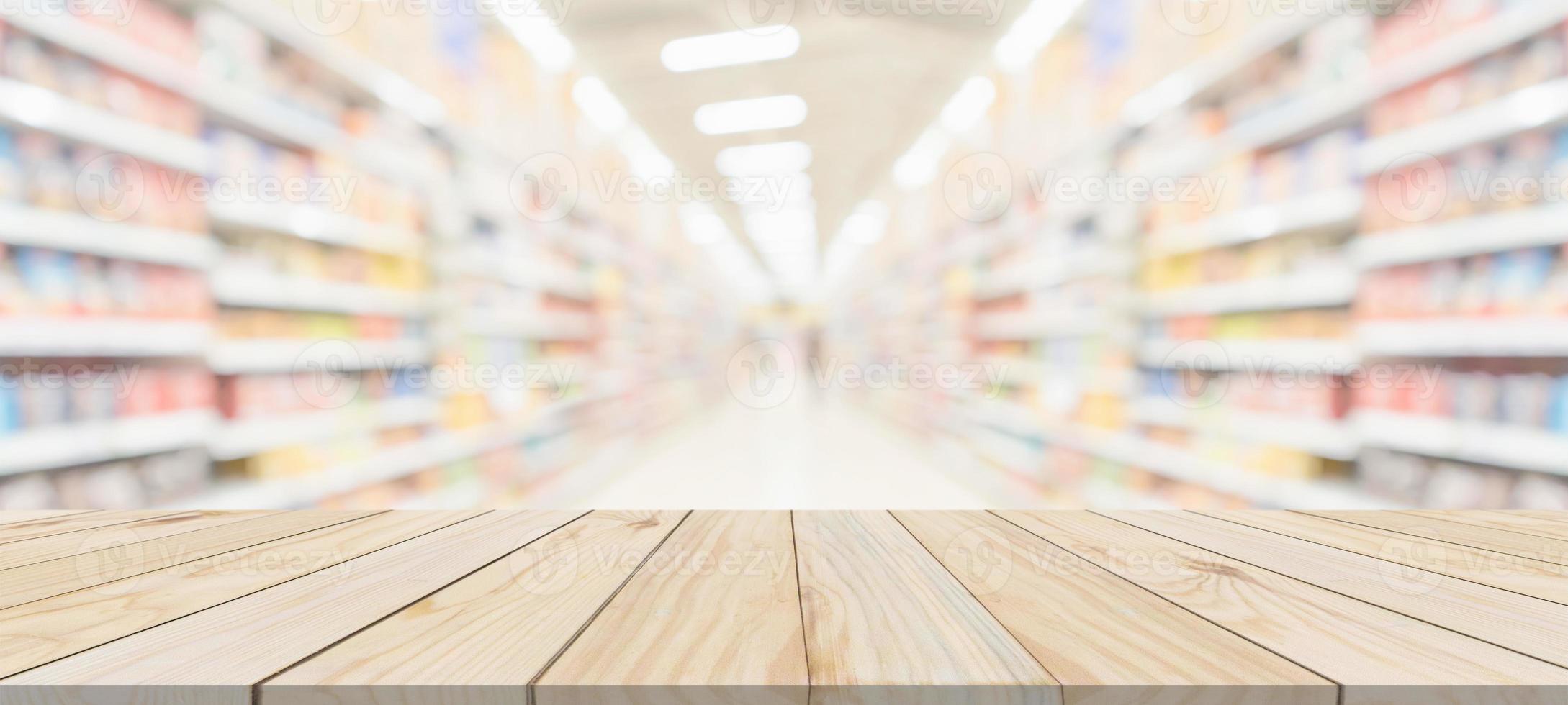 Wood table top with supermarket grocery store aisle interior blurred background with bokeh light for product display photo