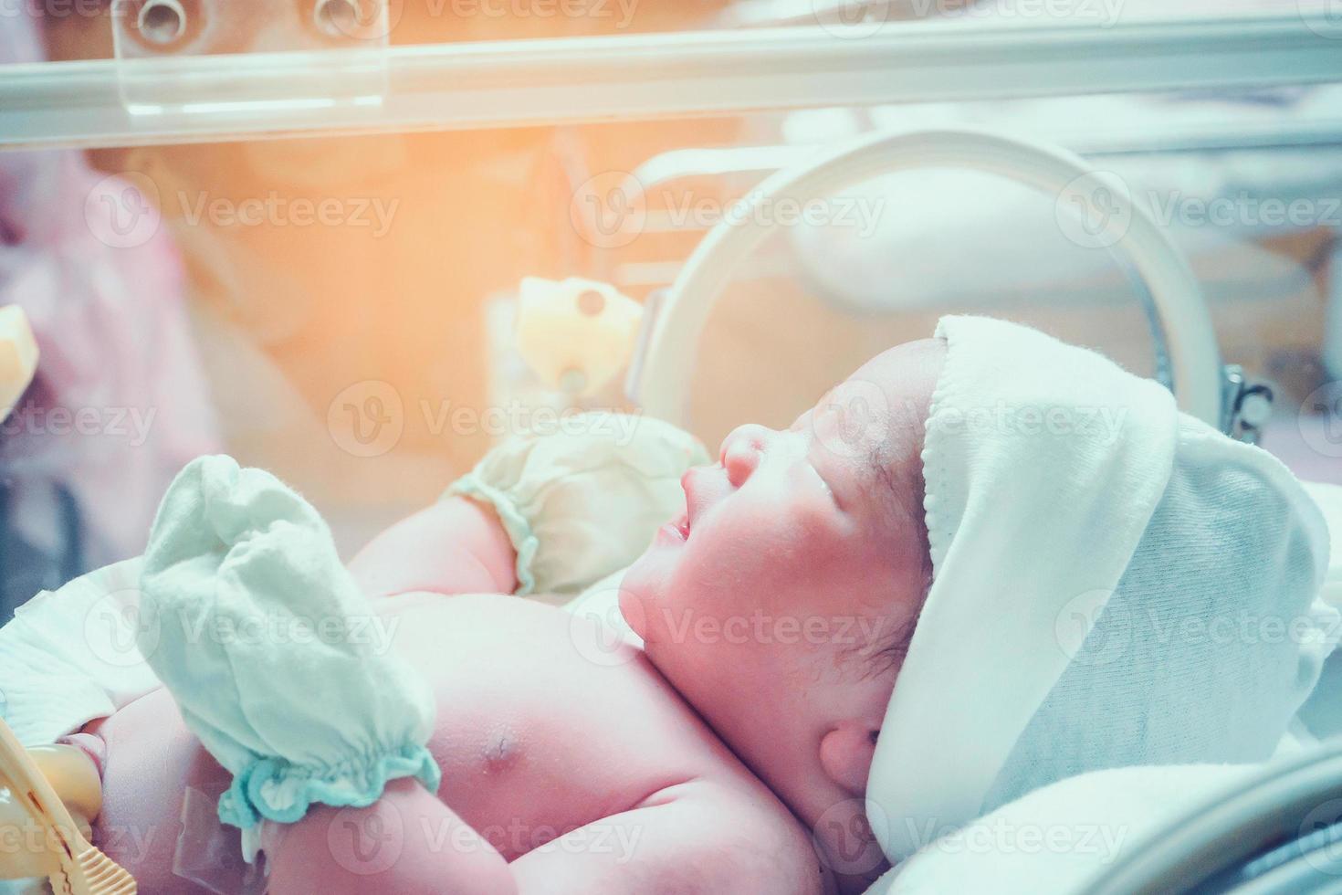 new born baby infant sleep in the incubator at hospital photo