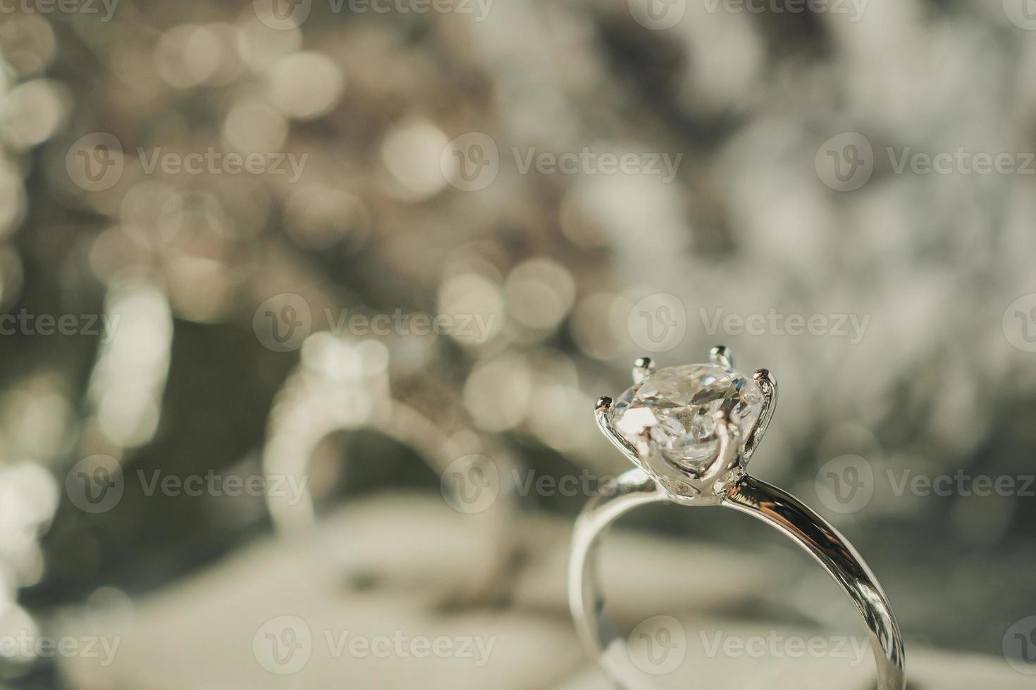 anillo de diamantes de compromiso de lujo con fondo abstracto de luz bokeh foto