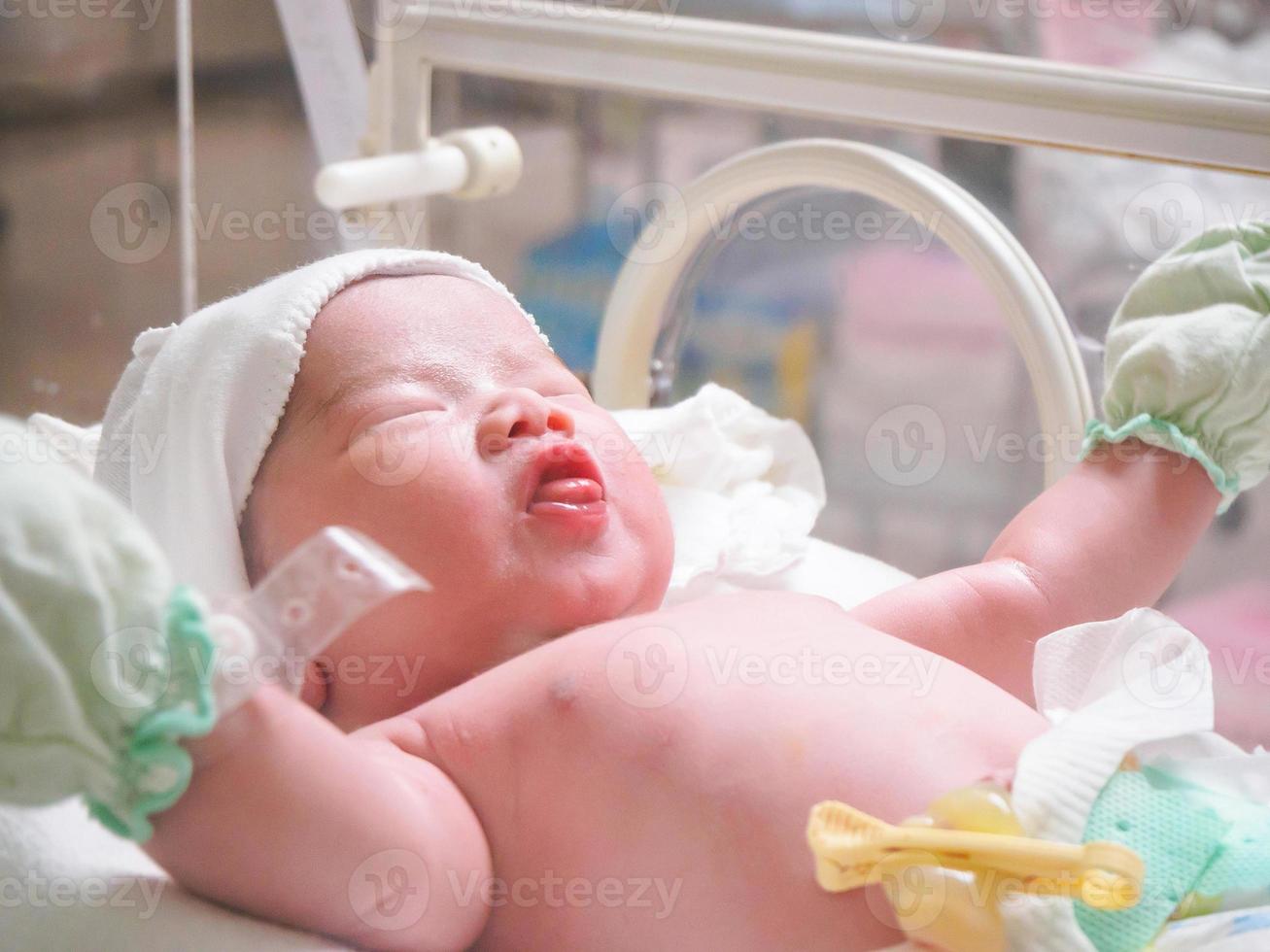 new born baby infant sleep in the incubator at hospital photo