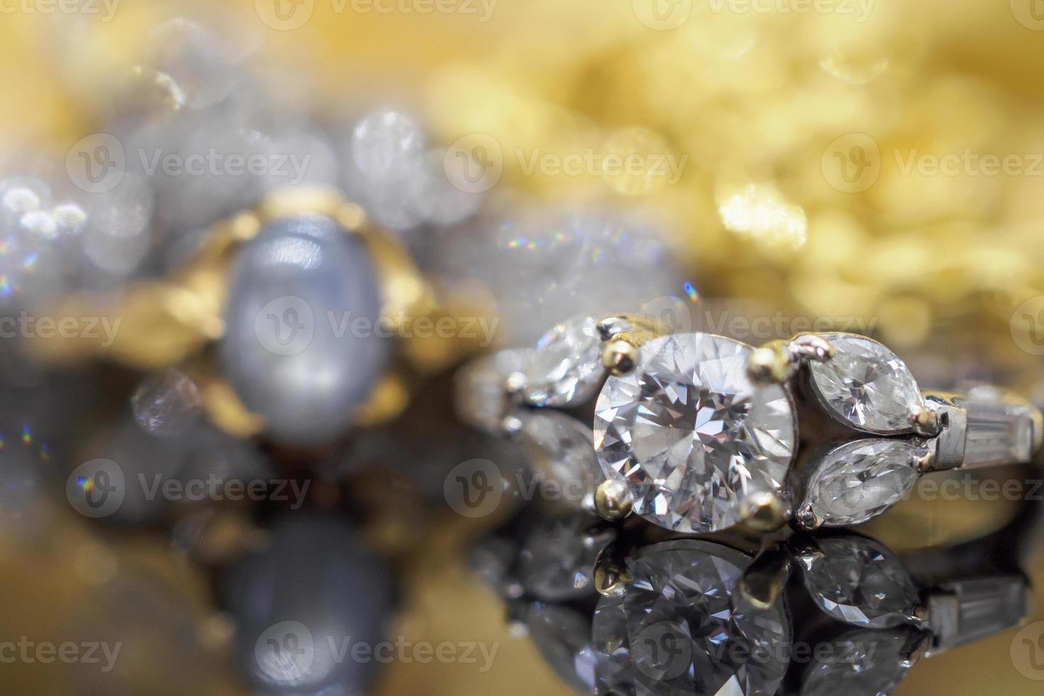 anillos de diamantes de joyería de oro de lujo con reflejo en el fondo negro foto