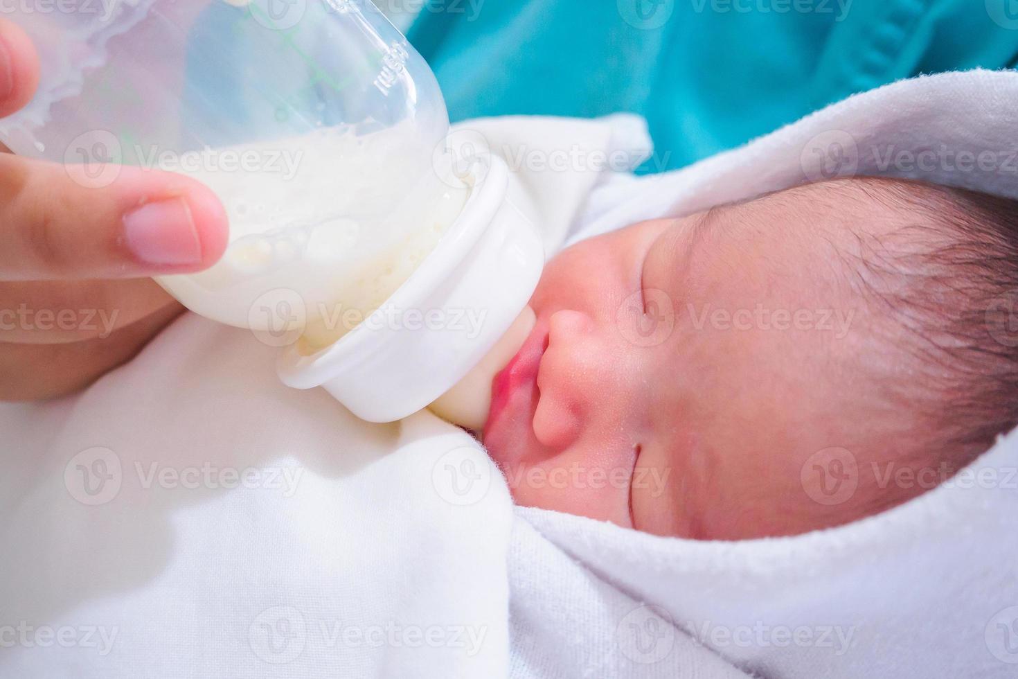 Mother feeding newborn baby from the bottle photo