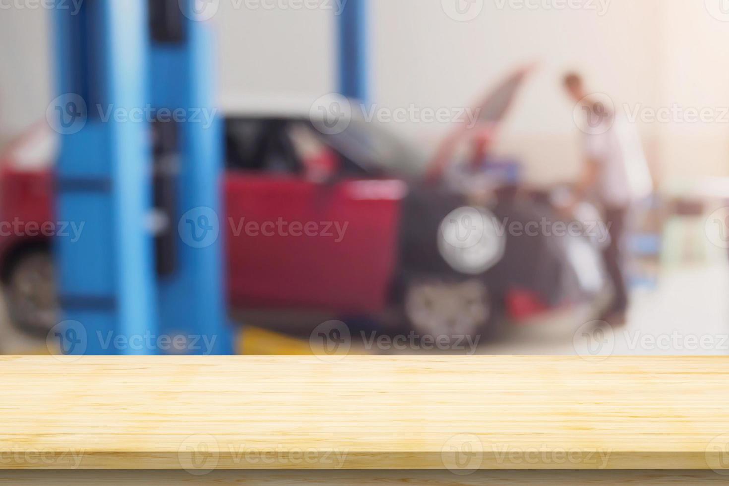Empty wood table top with car service centre auto repair workshop blurred background photo