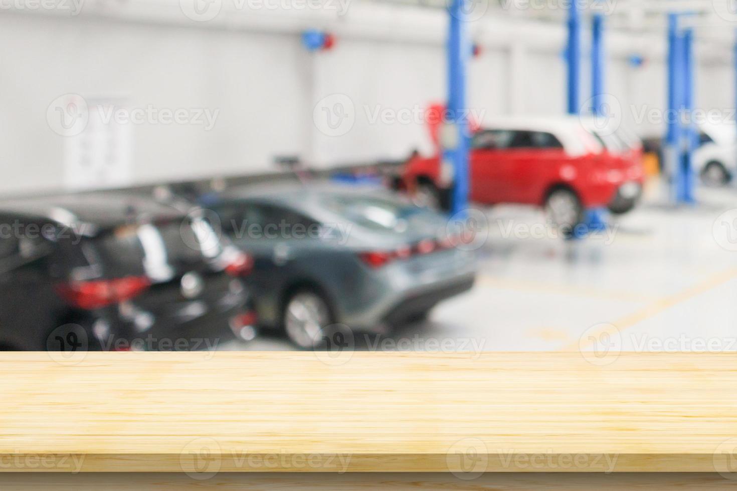 Empty wood table top with car service centre auto repair workshop blurred background photo
