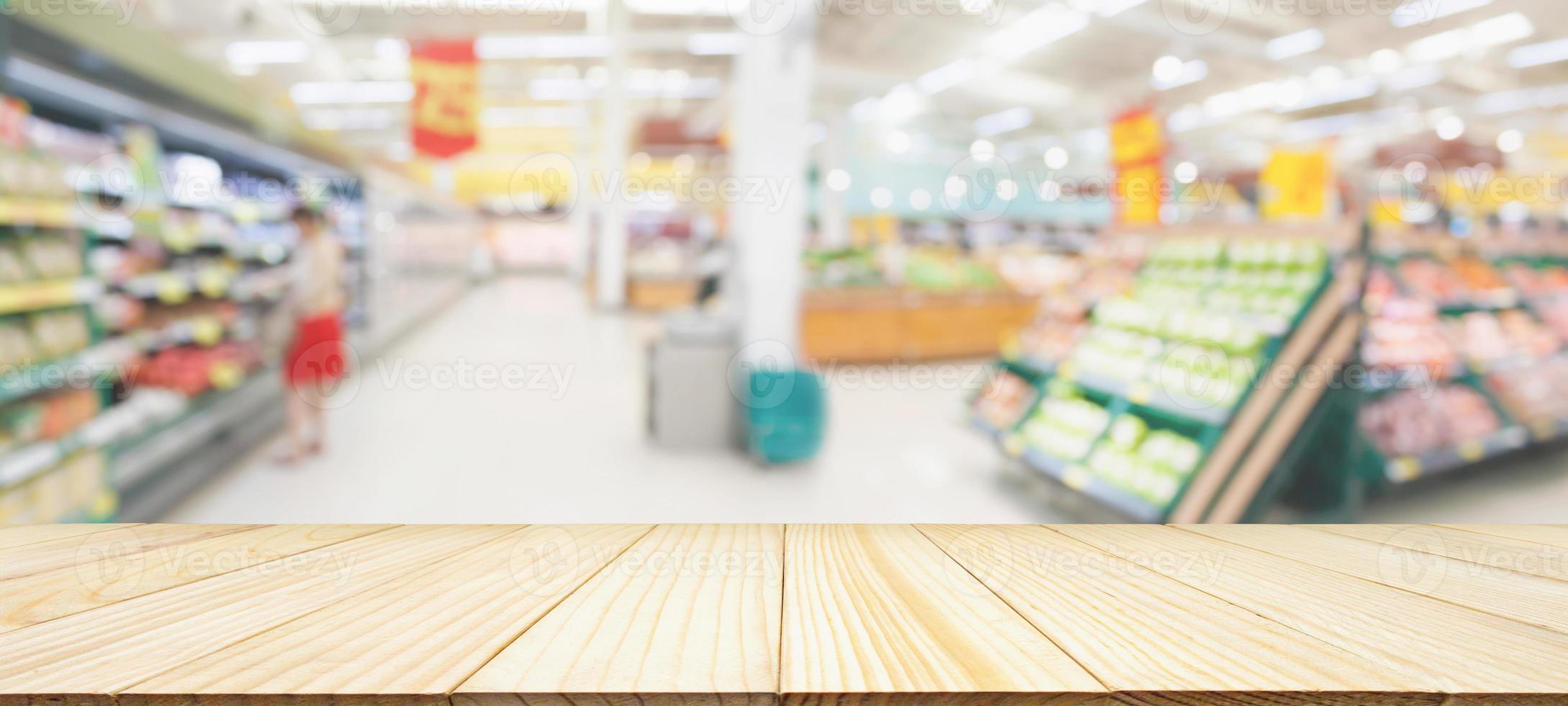 Wood table top with supermarket grocery store blurred defocused background with bokeh light for product display photo