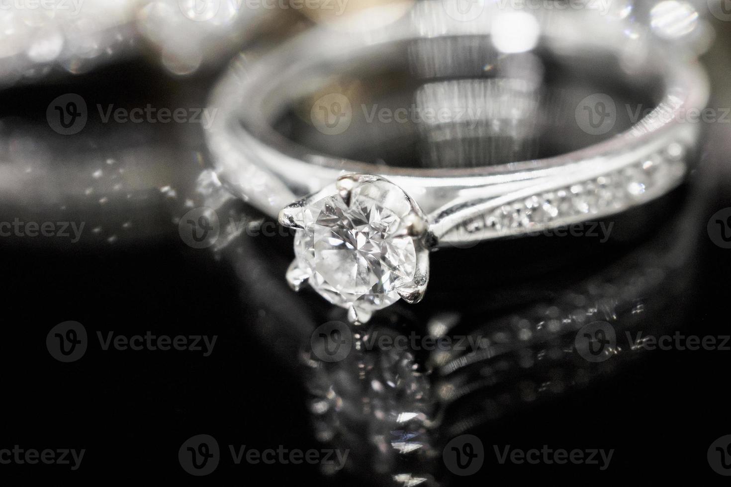 Jewelry diamond rings with reflection on black background photo